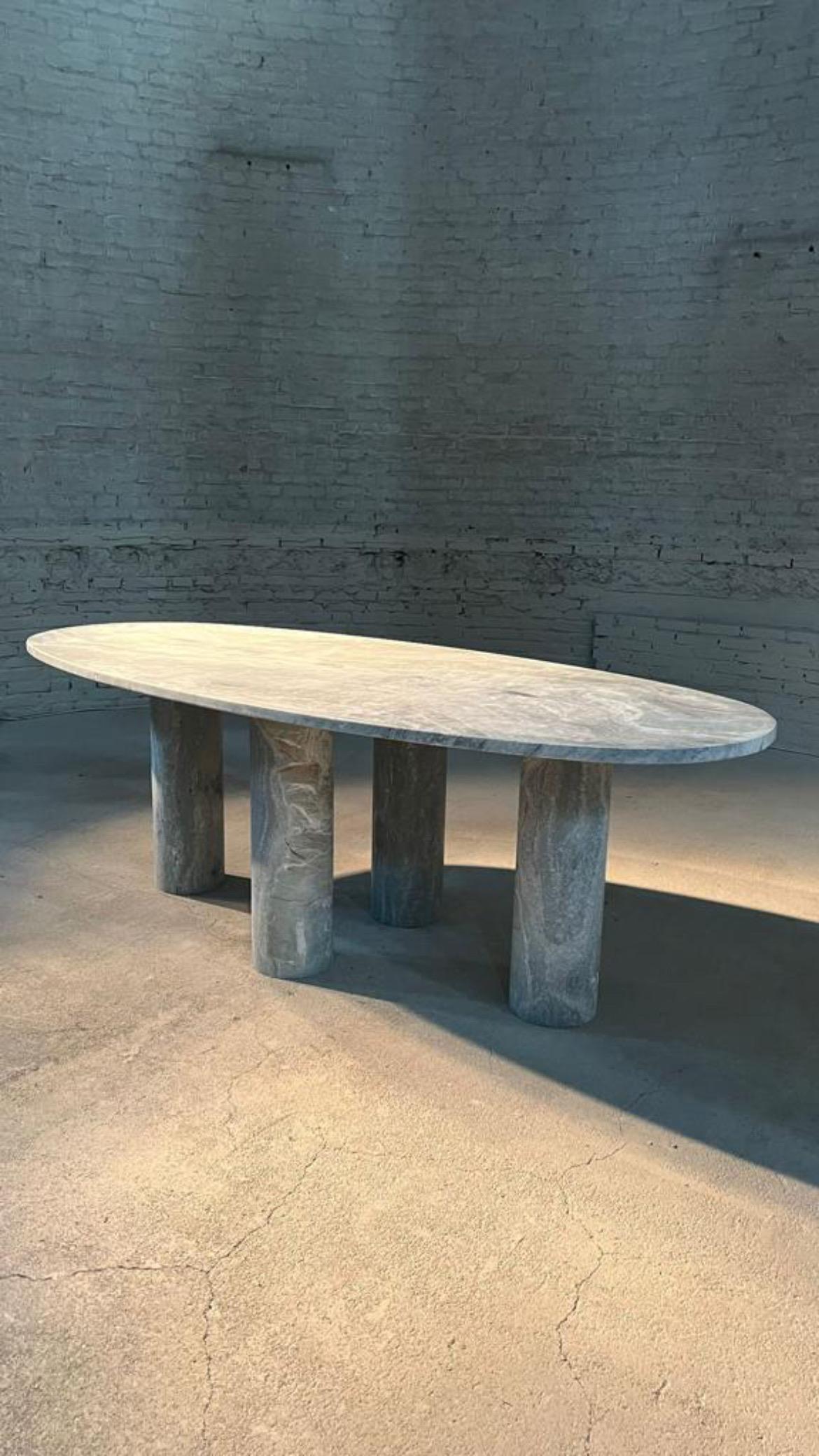 This minimalist table is made from one material, featuring an oval horse track top in green marble with white veining that elegantly sits on four cylindrical columns. 

Drawing inspiration from the vintage pieces of Mario Bellini, the column legs
