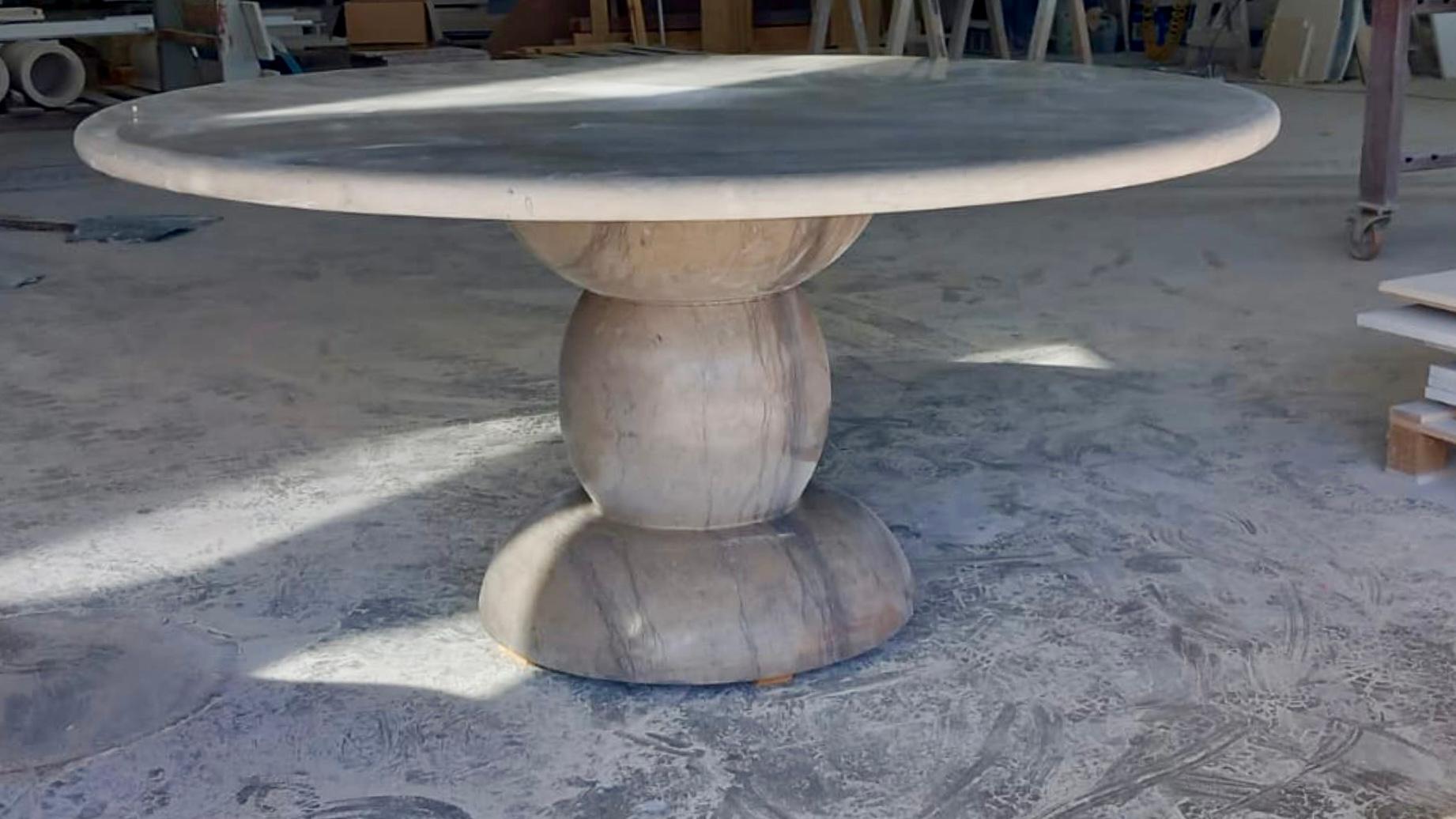 This minimalist outdoor table is made from one material, featuring a sculptural base, giving this table an organic feel with subtle details. 

The honed matt finish is durable and enhances the richness of the beautiful natural colour.

The