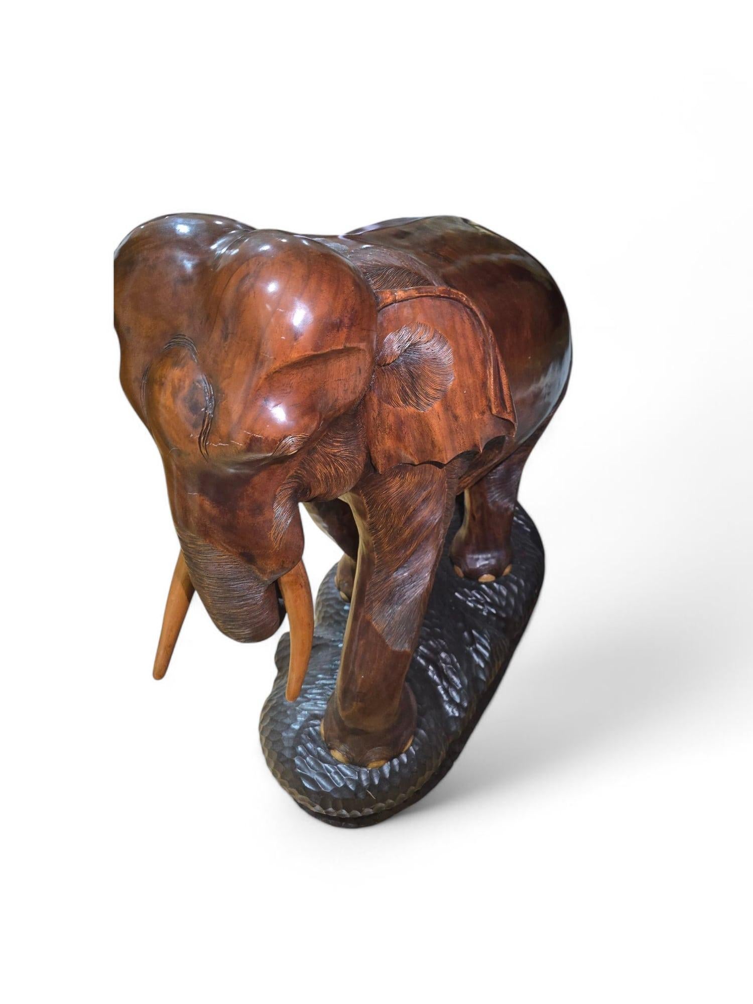
Impressionante e altamente decorativa scultura di elefante di grandi dimensioni degli anni '50, magistralmente scolpita in legno massiccio con notevole attenzione ai dettagli e al realismo. Questo pezzo sostanziale cattura la presenza maestosa
