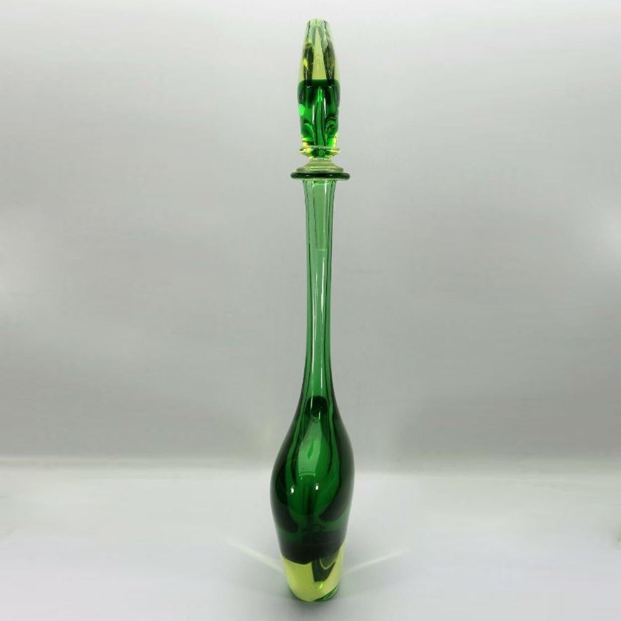 Large carafe with stopper in the popular Sommerso technique, the design was either by Flavio Poli or by Mario Pinzoni for Seguso Vetri d'Arte in the 1950s-1960s. Green, uranium-containing glass with a yellow overlay in a very elegant teardrop shape.