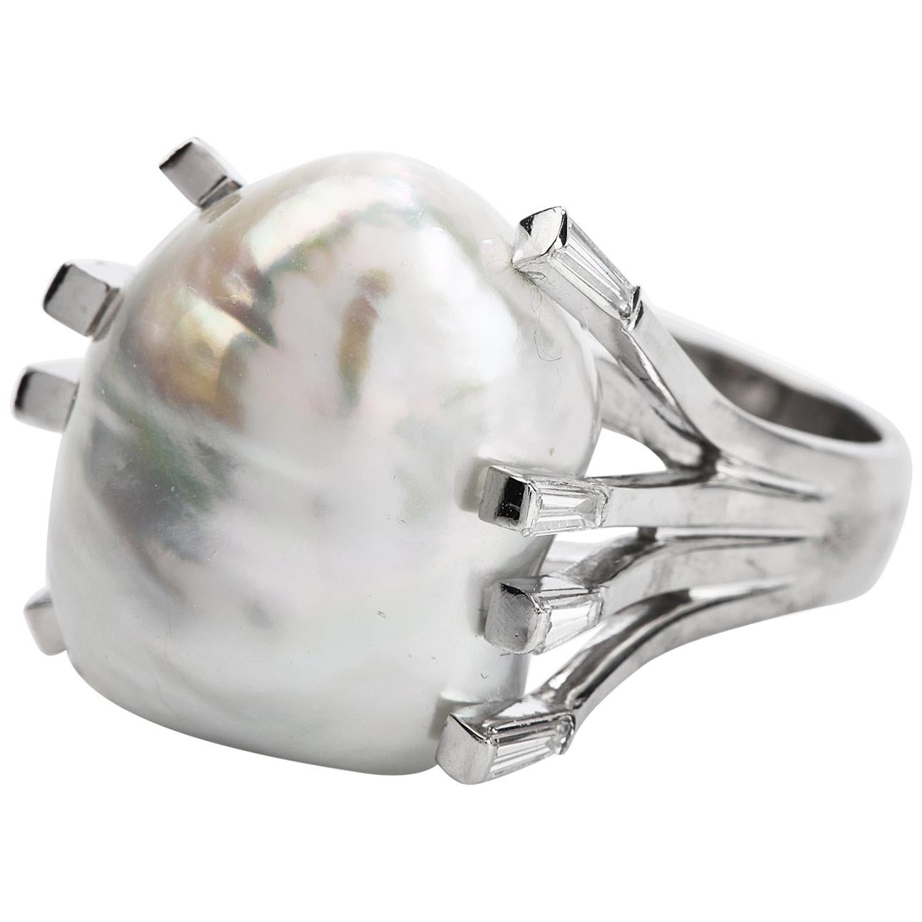 This cocktail ring boasts one large spectacular 22 mm x 19 mm white saltwater pearl set in eight 

 Weight: 22.2 Grams.

Size: 7.75

Measurements:21mm x 17mm

Metal: Platinum

Gemstone:  Genuine diamonds, 8 baguette cut, channel set, 0.70 carats G-H