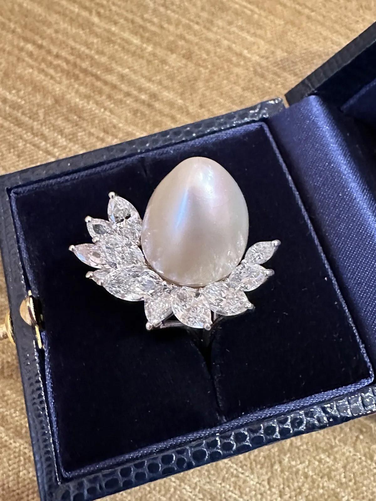 Large South Sea Pearl & Diamond Cocktail Ring in Platinum 

Large Pearl and Diamond Ring features one large, tear-drop-shaped, white-ivory-colored South Sea Pearl, approximately 15 mm in size, offset on one side by 11 Marquise Diamonds graduating in
