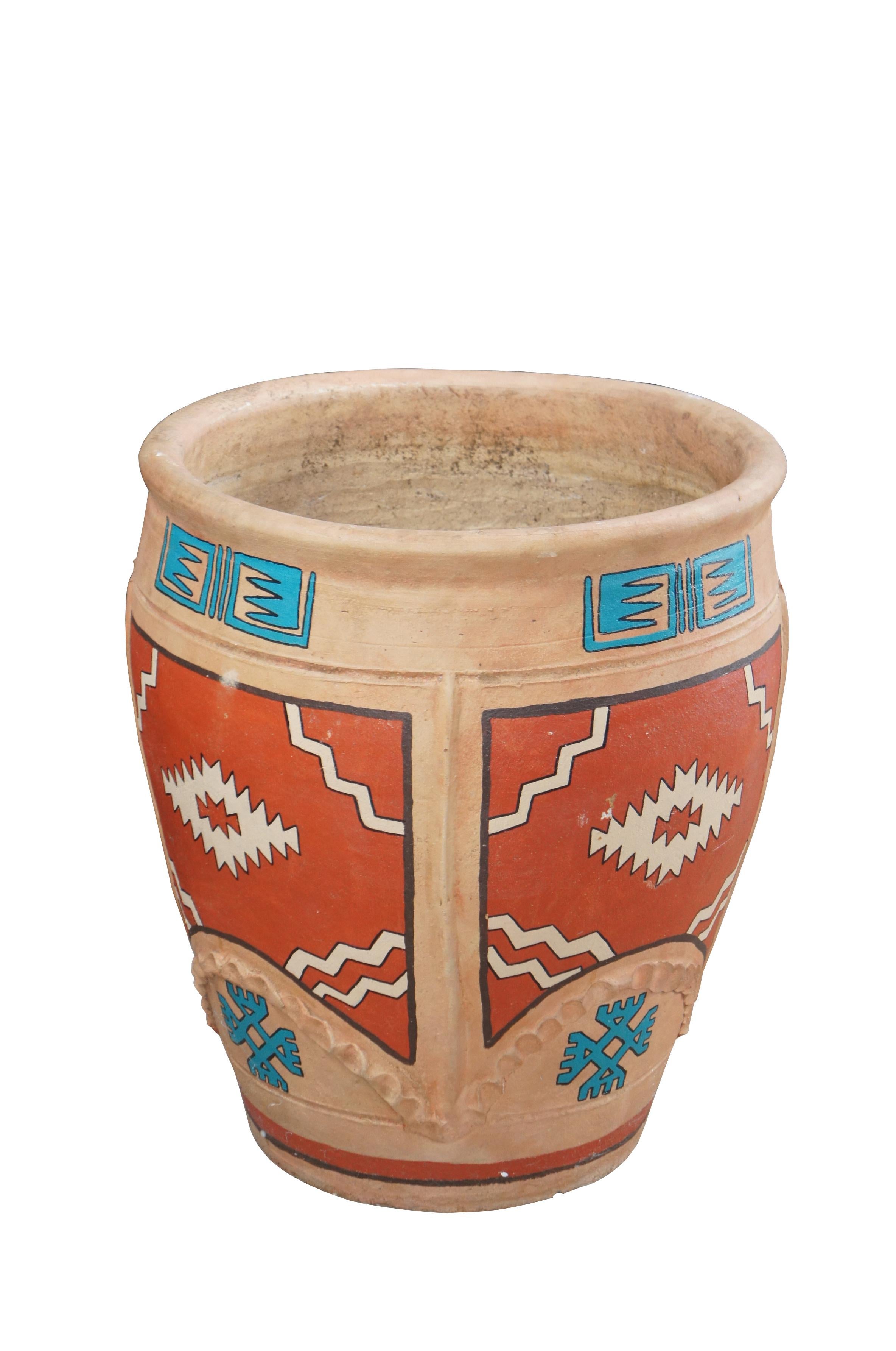 Vaso in terracotta dipinto a mano, vaso o fioriera da giardino.  Presenta una forma a urna con disegni geometrici in rosso e turchese con contorni neri.  Il vaso non è contrassegnato.  

Dimensioni:
19