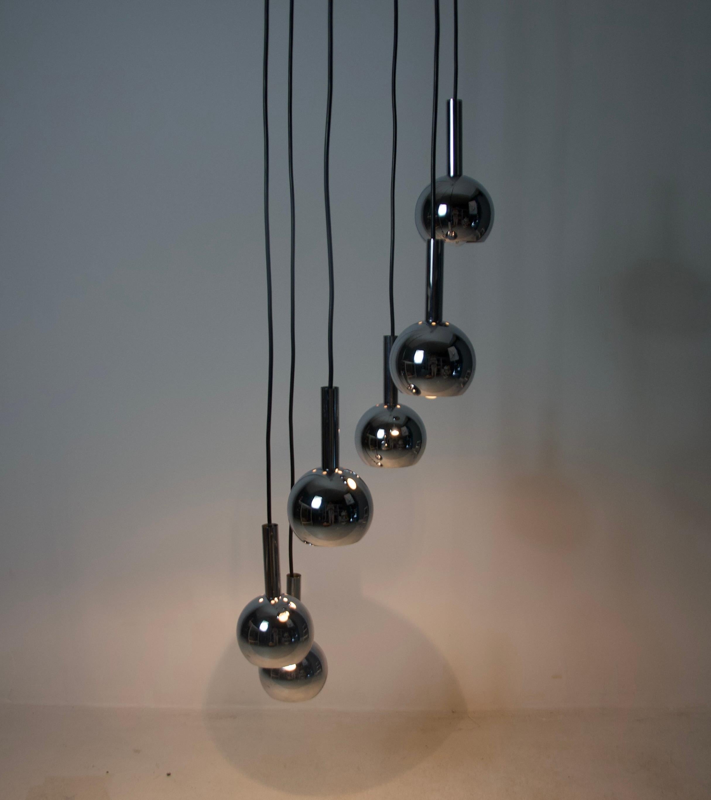 Stunning Space Age cascading ceiling lamp from the 1970s, featuring six metal shades in a sleek, futuristic design. This iconic piece captures the essence of the Space Age era, with its clean geometric shapes and chrome metallic finish, evoking the
