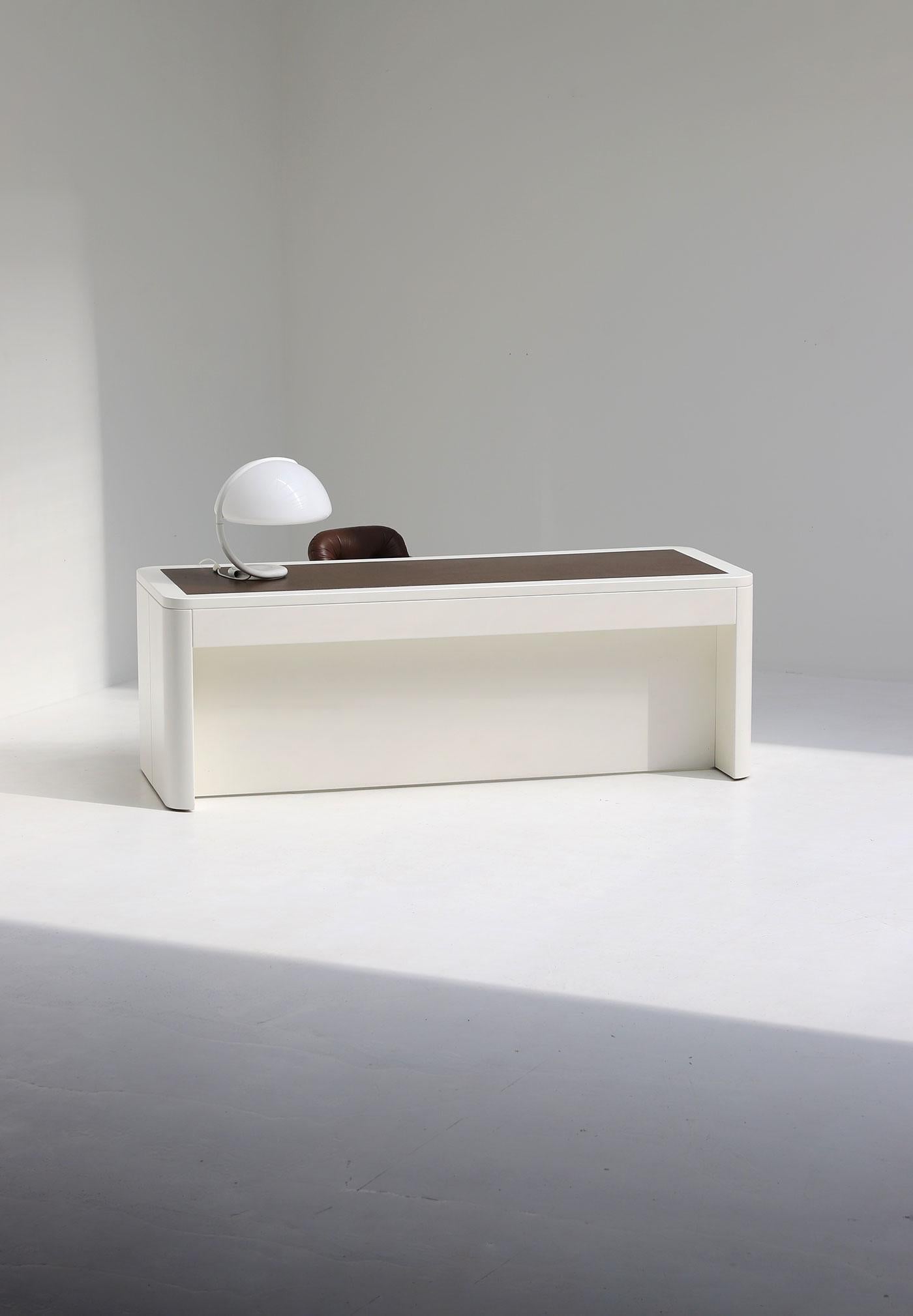 This large space age desk is dating is designed by Frank De Clercq in 1972. A minimalist yet modern design with a simple rectangular shape and rounded corners. The desk is build out of solid wood and plywood with a white lacquered finish. The desk