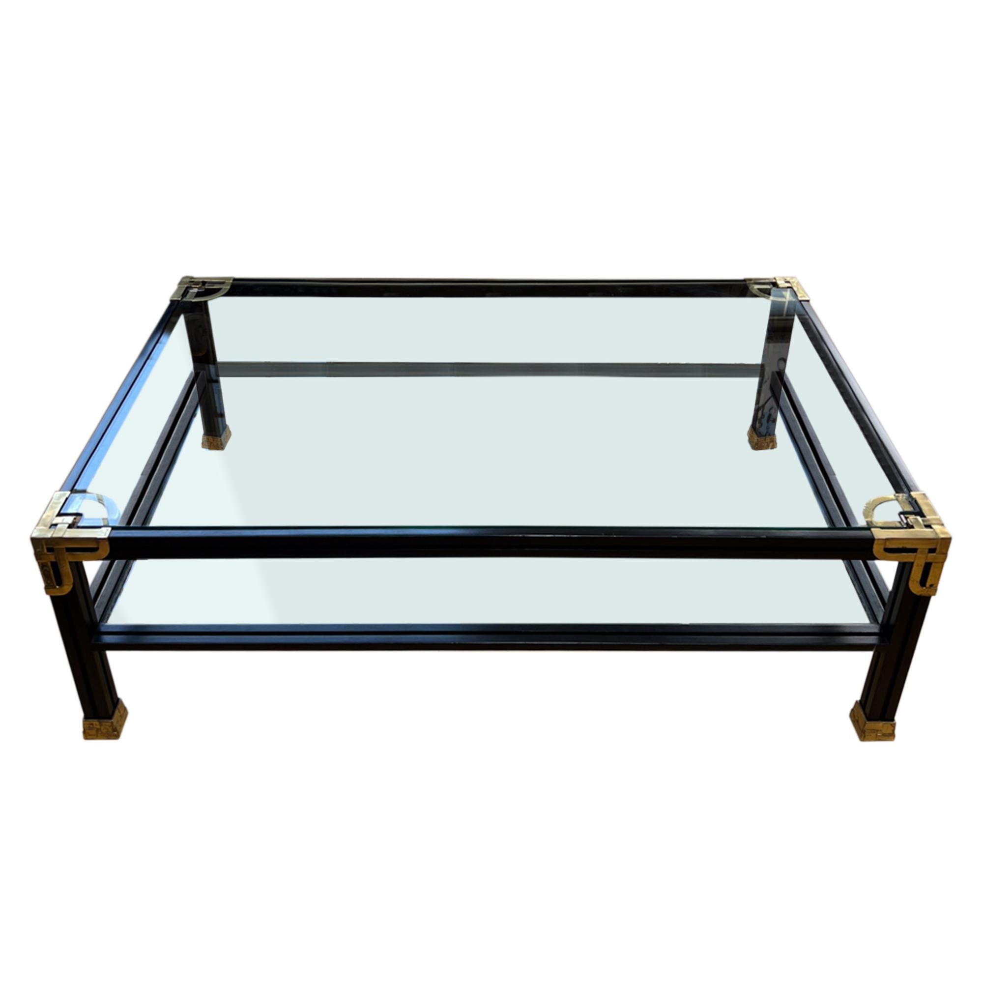 This grand scale two tier coffee table was made in Spain in the 1970s by the furniture designer Valenti.

The ebonised wood is decorated with brass and the shelves are clear glass. The lower shelf is 24cm high.

Valenti was originally a silversmith