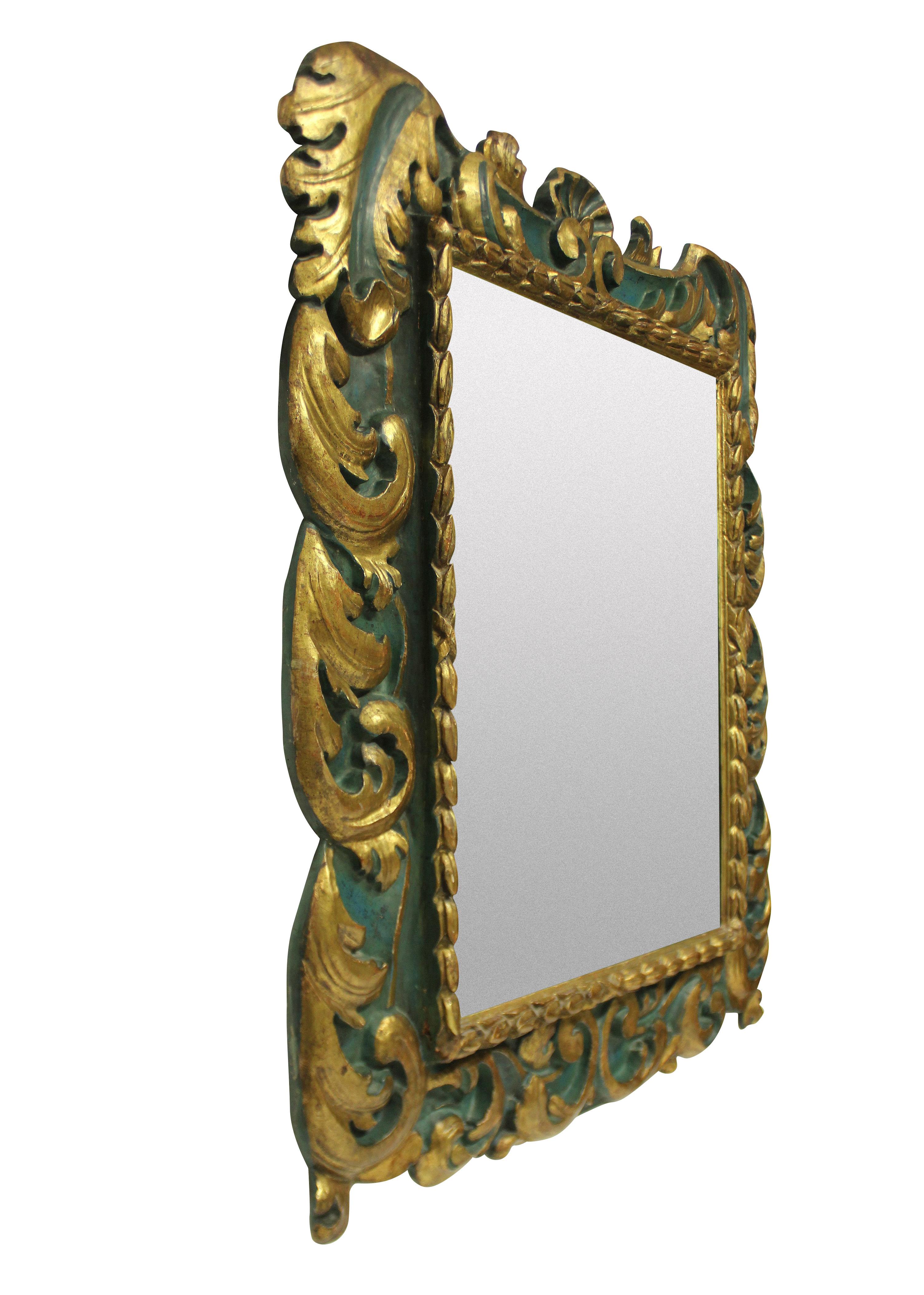 A large Spanish decorative, carved, painted and gilded mirror, with blue/green paints and a later plate.