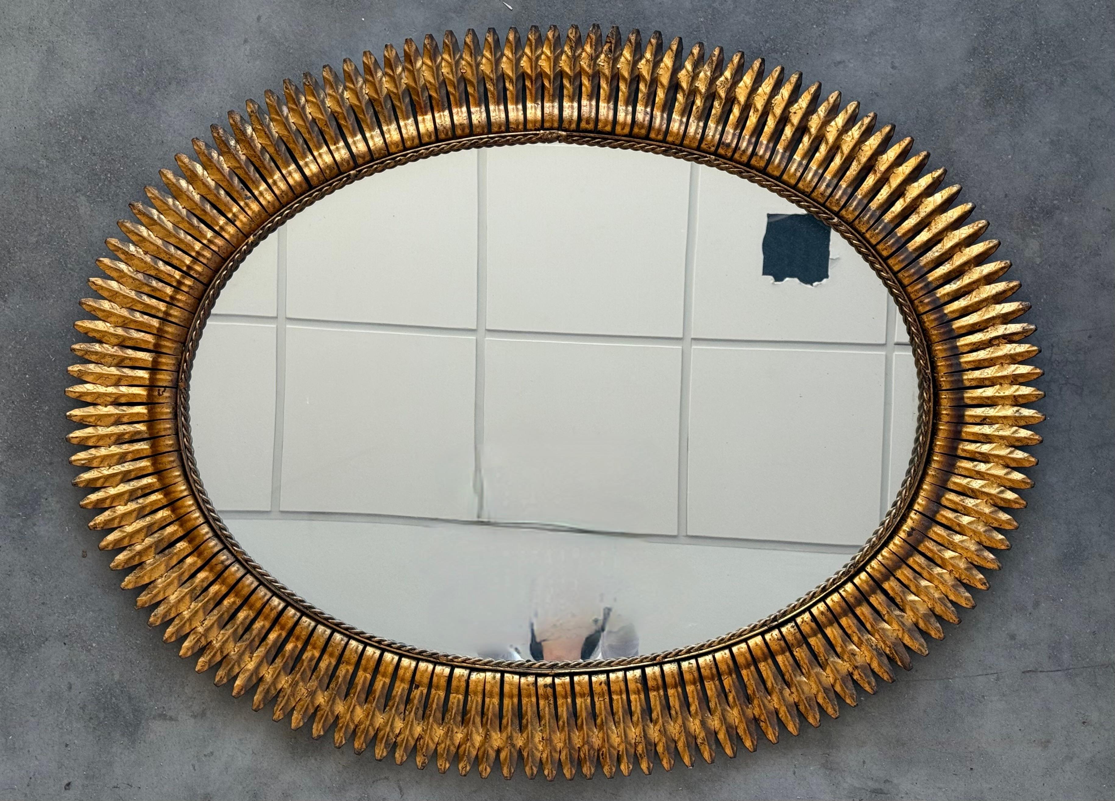 Specchio ovale spagnolo degli anni '50 in metallo dorato con cornice a foglia stretta.


