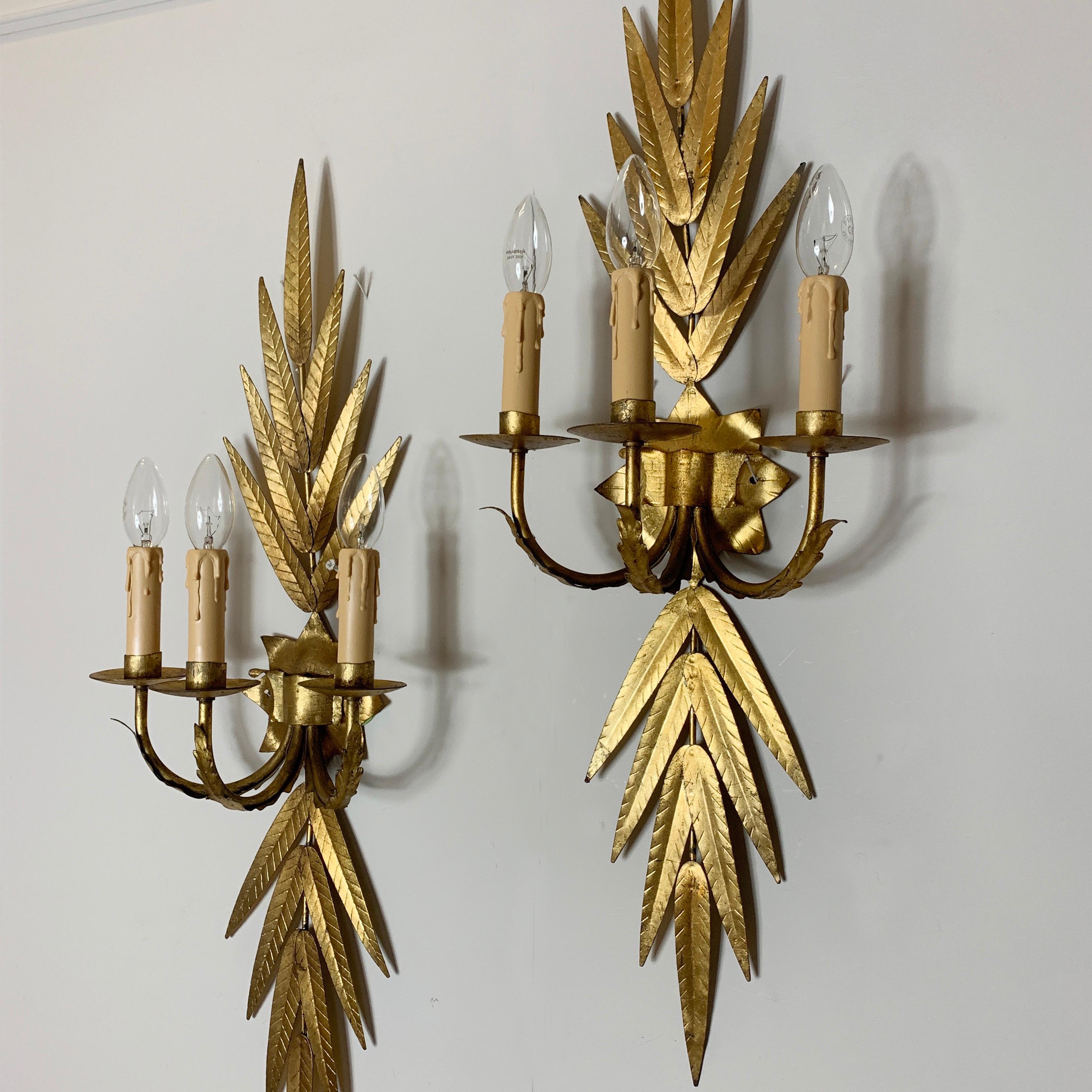 A Pair Of Large Spanish Gilt Wall Sconces att 'Ferro Art' ' Ferro Colour' Spain, 
circa 1950s
Beautiful Strong Bright Gilt Color, No Losses, Great Condition
The Lights Have Been Re-Wired And Pat Tested Ready For Use
90Cm Height, 27Cm Width, 18Cm