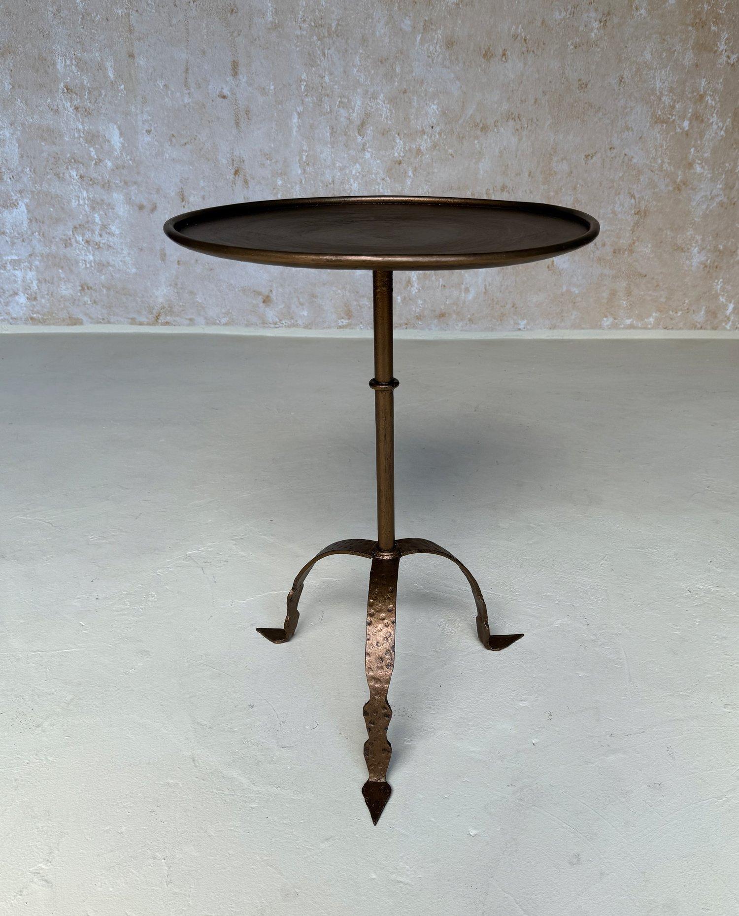 This large iron side or drinks table was recently hand-crafted by European artisans using traditional iron working techniques. It features a sturdy central stem with a decorative ring detail mounted on a sturdy hammered tripod base with pointed feet