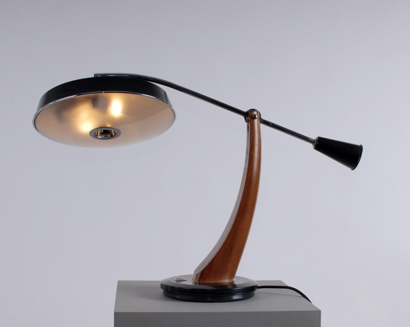 Spanish Mid-Century Modern adjustable metal and oak desk table lamp by Fase.
Manufactured by Fase Spain 1960s lamp with lacquered oak stand on black metal base, chrome arm with counter balance weight, black shade with opaline glass. 2 light bulbs.
