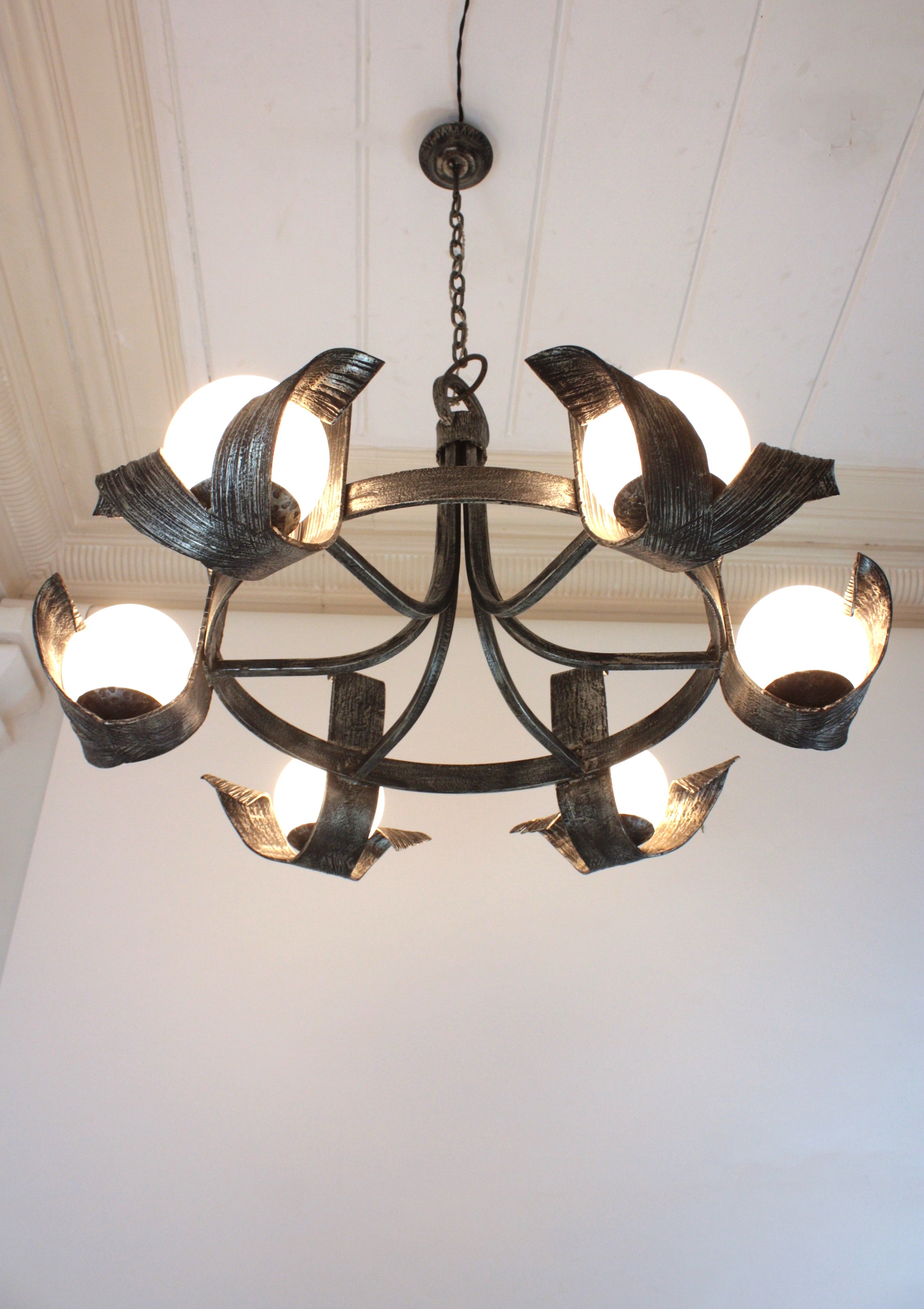 Lustre espagnol à grandes volutes avec 6 globes en verre au lait, fer forgé
Remarquable lustre/plafonnier encastré à six branches en verre, en fer doré à la feuille d'argent.
Fabriqué par Ferro Art, Espagne, années 1950.
Grande taille. Une