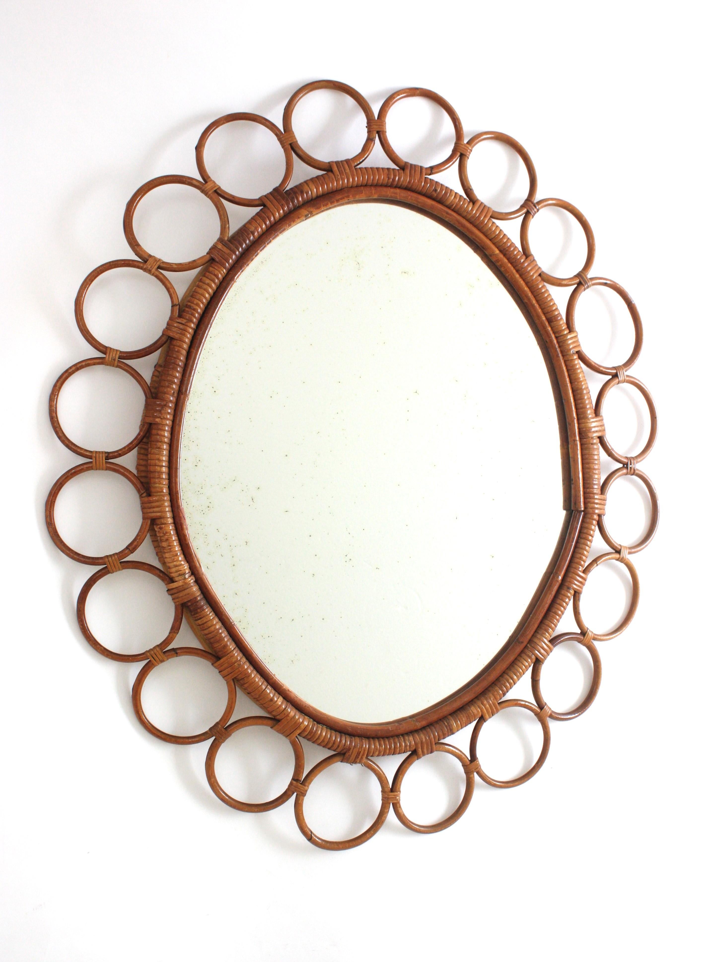 Grande specchio da parete ovale del Medioevo, rattan, bambù, vimini, Spagna, anni '60
Accattivante specchio in rattan incorniciato da anelli o cerchi in rattan collegati tra loro. L'anello centrale che circonda il bicchiere è avvolto da un nastro di