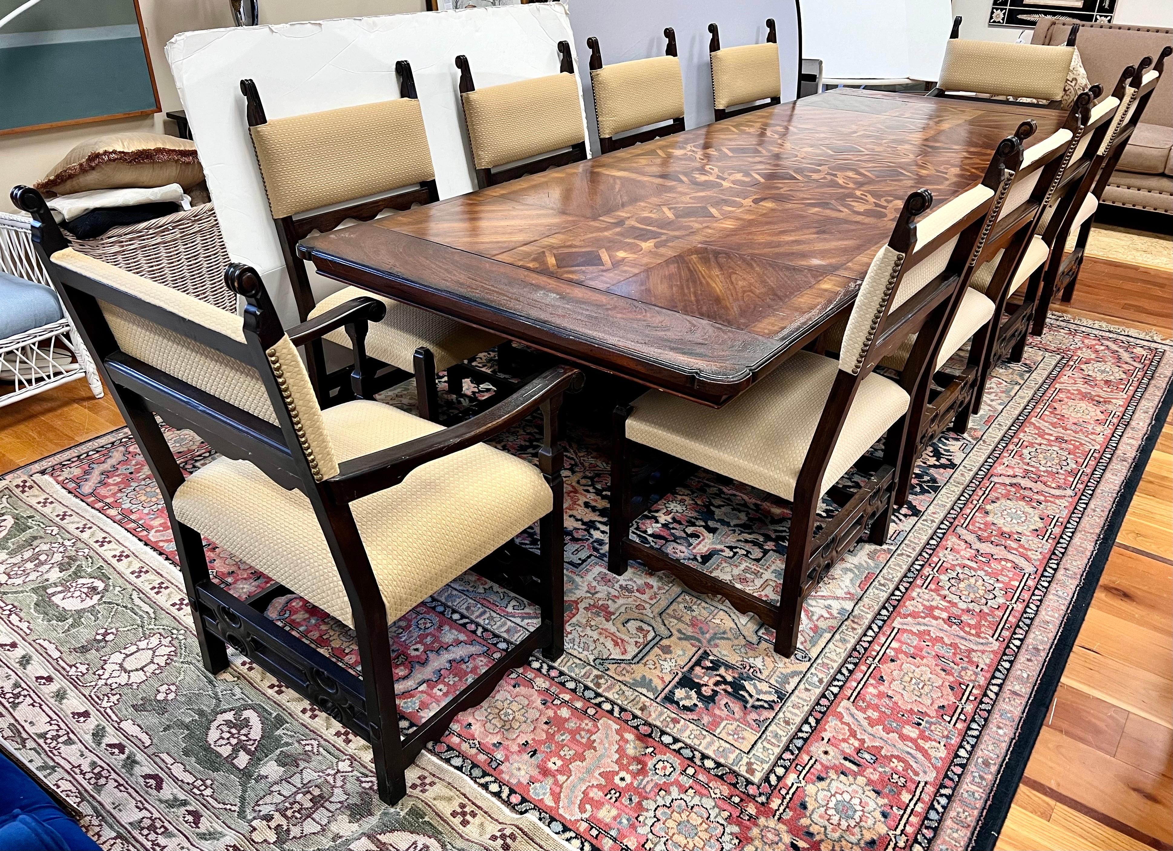 A spectacular dining set which includes a walnut trestle table with beautiful marquetry pattern at top, see pics - really one of a kind.  Table expands when the two leaves are included which slide in at each end versus the middle.  There are 10