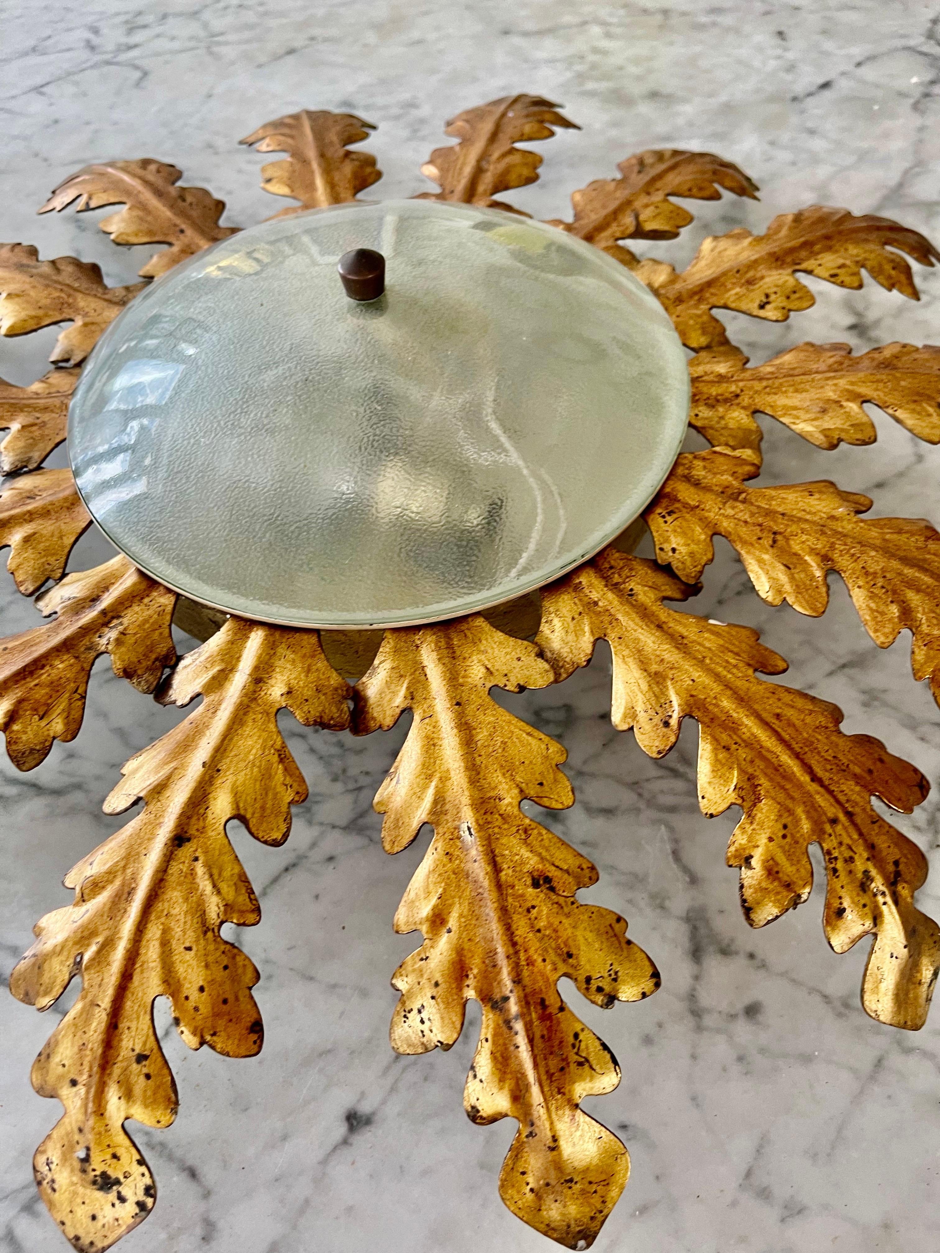 Grande lampe espagnole en métal doré et verre dépoli, Espagne, années 1950. Cadre ou suspension en fer doré du milieu du siècle dernier avec des motifs de feuilles de laurier entourant un diffuseur central en verre dépoli. Fabriqué à la main en fer