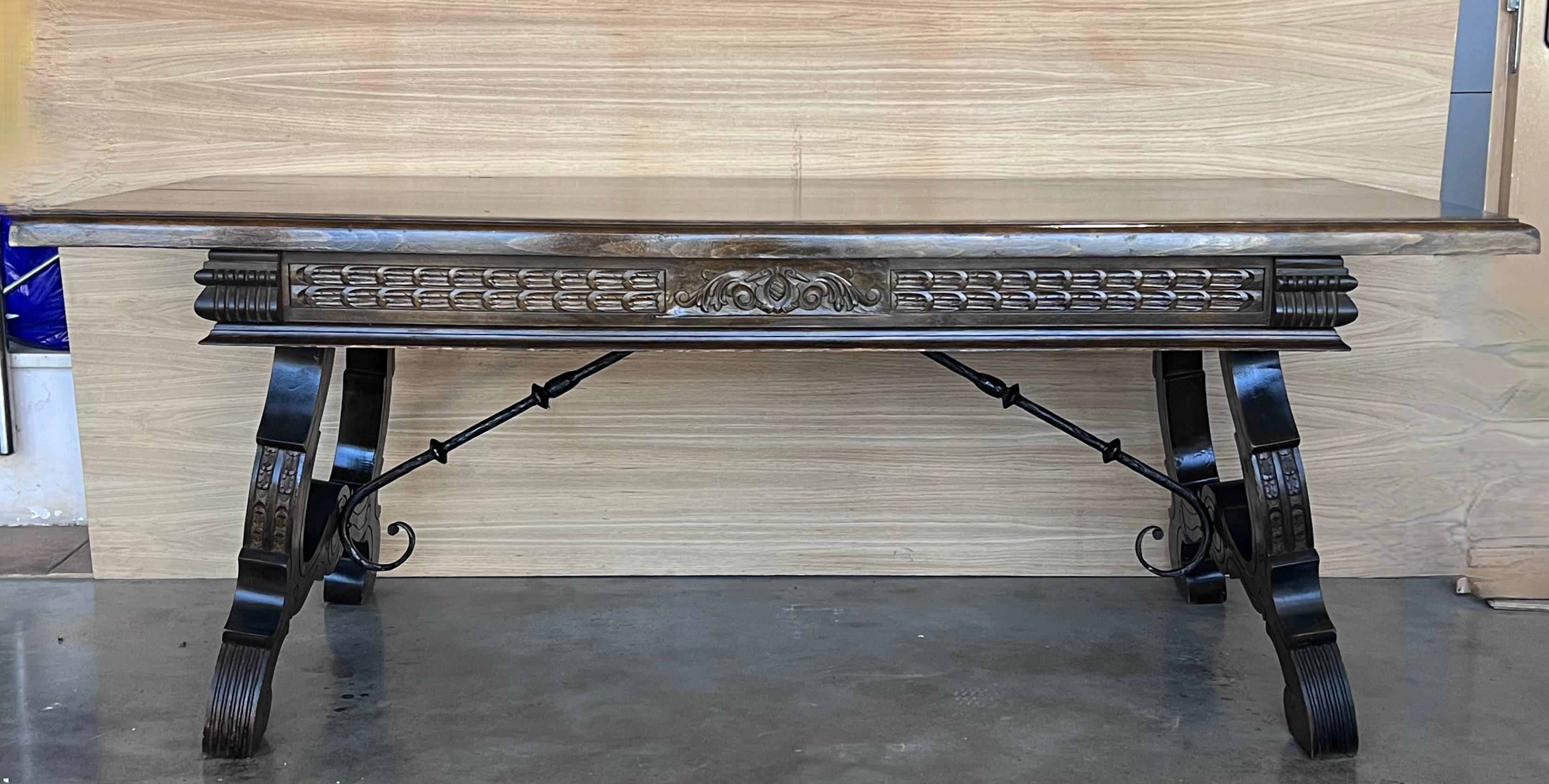 Handsome walnut library piece that can be used as a desk or Work table. Made of walnut having carved gadrooned and lyre legs and a stretcher made of iron. Carved on all sides .
 19th century.


