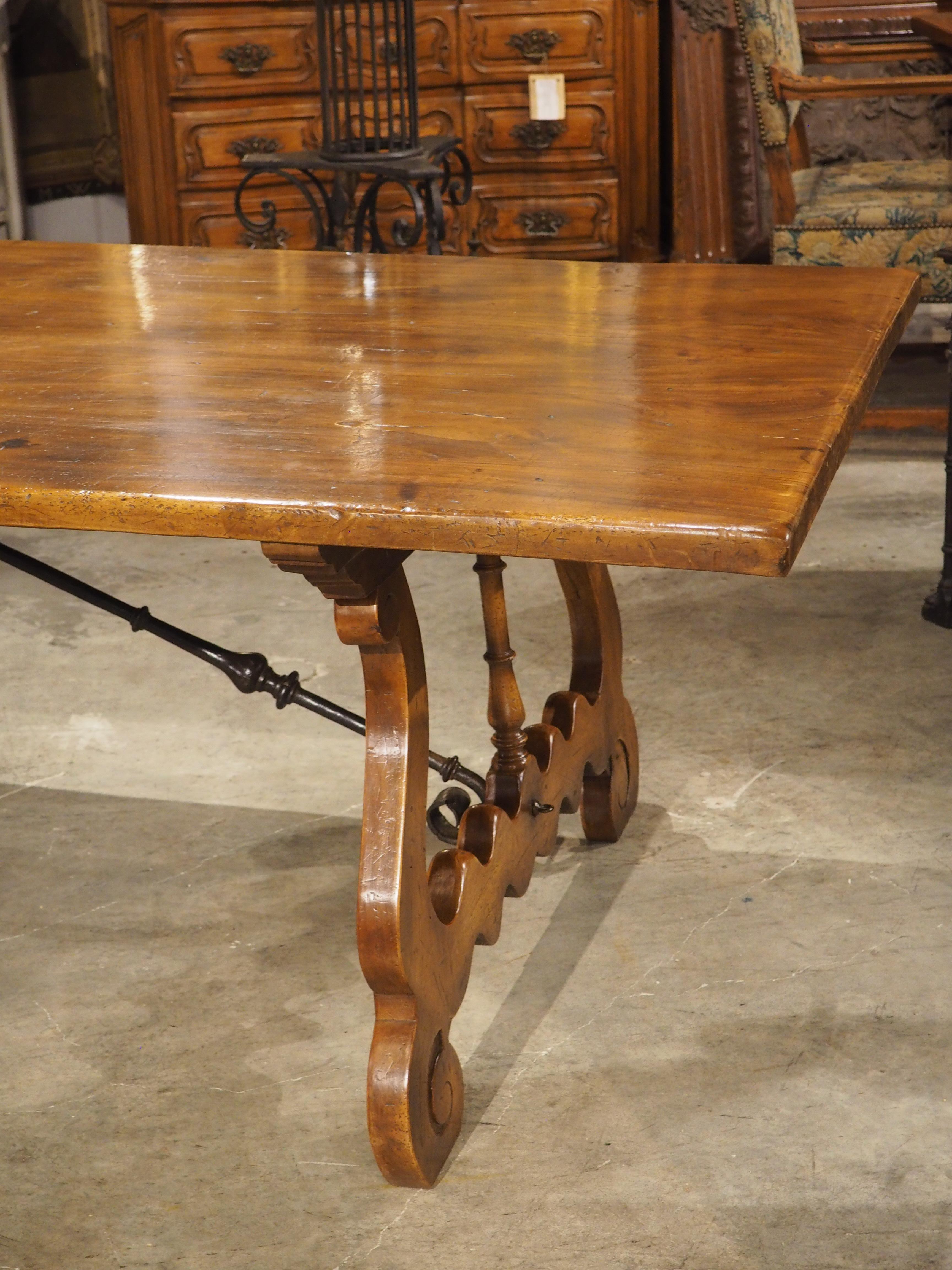 More information coming soon…

A magnificent Spanish walnut dining table, dating to circa 1900.  The 117+ inch long table is supported by wide, open lyre legs with sinuous fretting above scrolled feet.  The legs are supported by a long iron