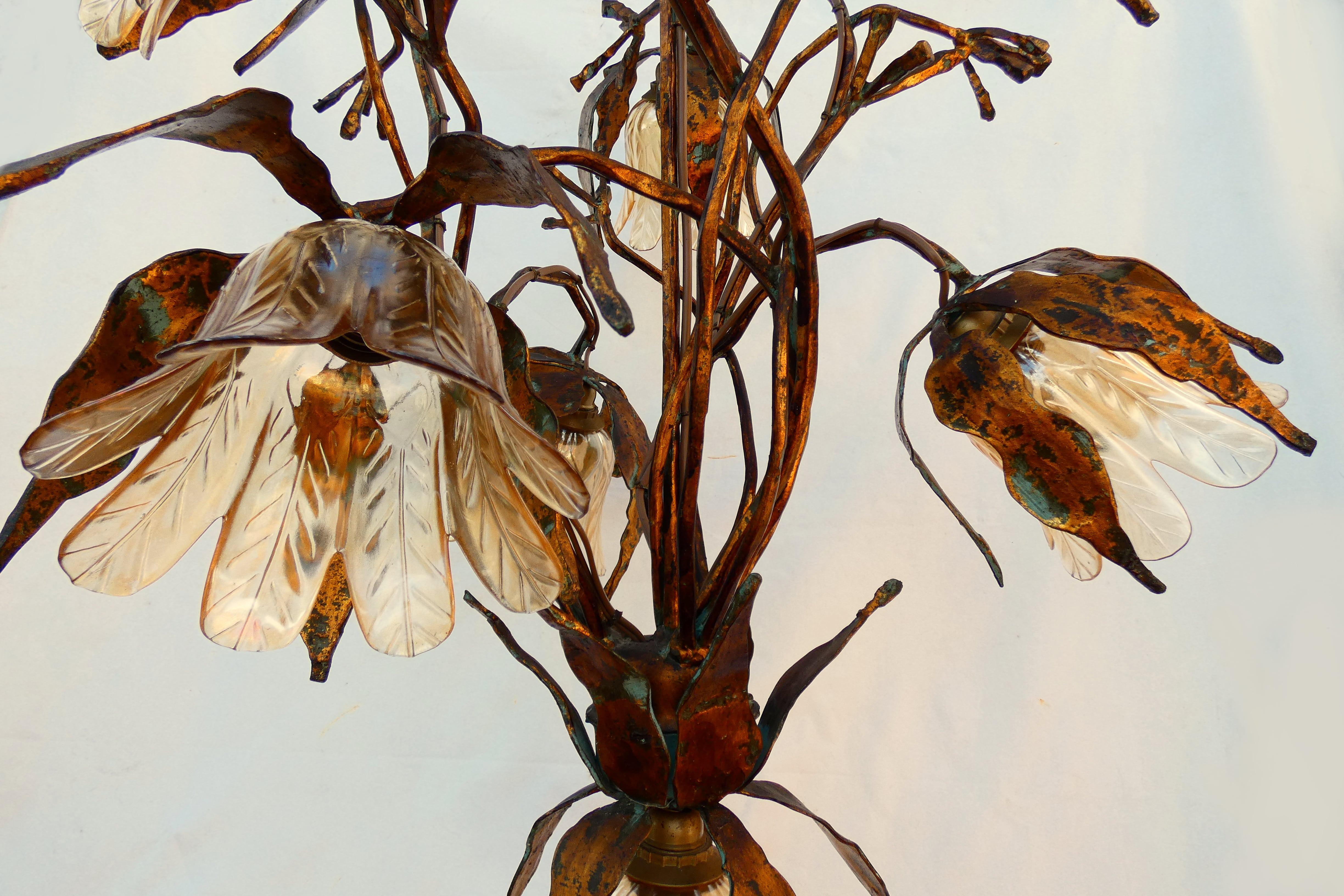 Spectacular lamp in forged metal with floral glass lampshades, showing elegant Art Nouveau lines combined with the strength transmitted by brutalist elements.