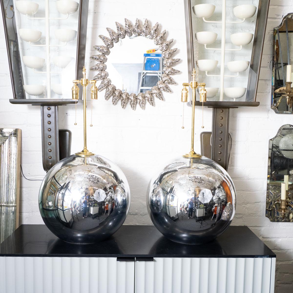 Large spherical mercury glass lamps with brass hardware. Three lamps available (an identical pair and one single). Single lamp sold at 29