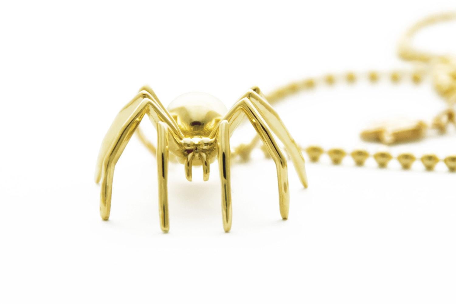 Nous vous présentons le grand pendentif araignée en or jaune massif, qui témoigne du profond symbolisme de la créativité et de l'autodétermination incarné par l'araignée. Réalisé avec la plus grande précision et le plus grand talent artistique, ce