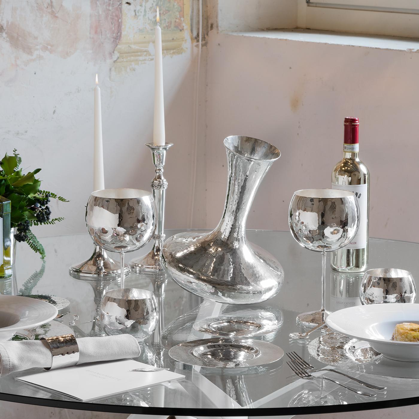 This large decanter's unique shape resembles a spinning top. It was designed to elevate liquor's bouquet and flavor. Made from silver, it is the perfect storage container due to the material's antibacterial and antimicrobial properties. Its design