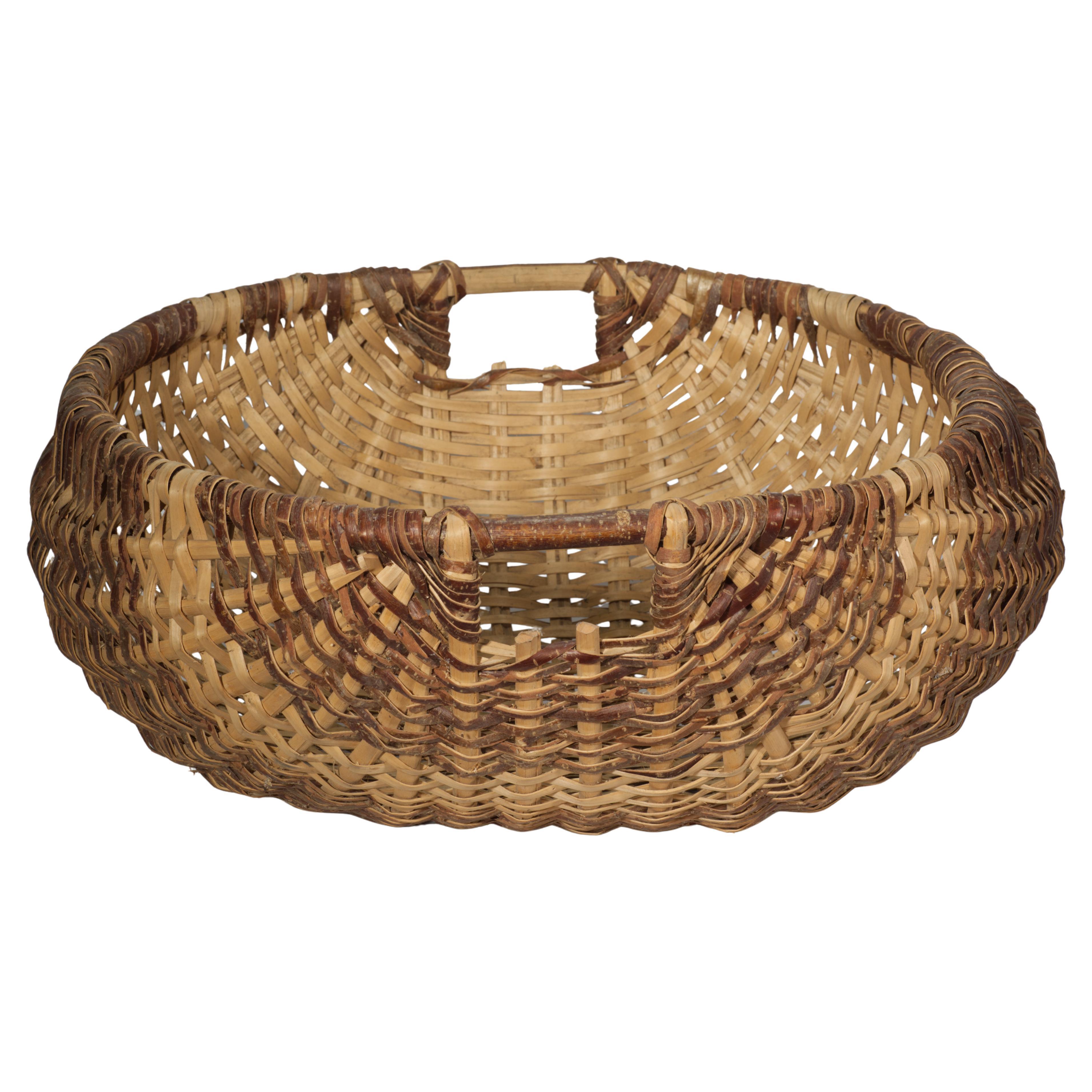 Vintage or antique oversized basket in a traditional spale shape features a bent wood ring rim with handles on each side. The basket is formed of a split oak with graphic weave pattern.

Spale, or oak swale, is a traditional basket shape used in