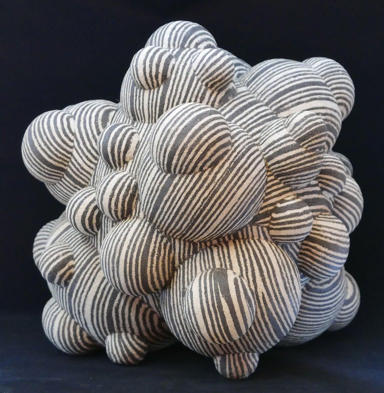 Large abstract spore sculpture made by Lewis Trimble from stoneware using the Nerikomi technique using various color clay bodies to build up the surface decoration. This one is done using high fire unglazed black and cream colored stoneware. The