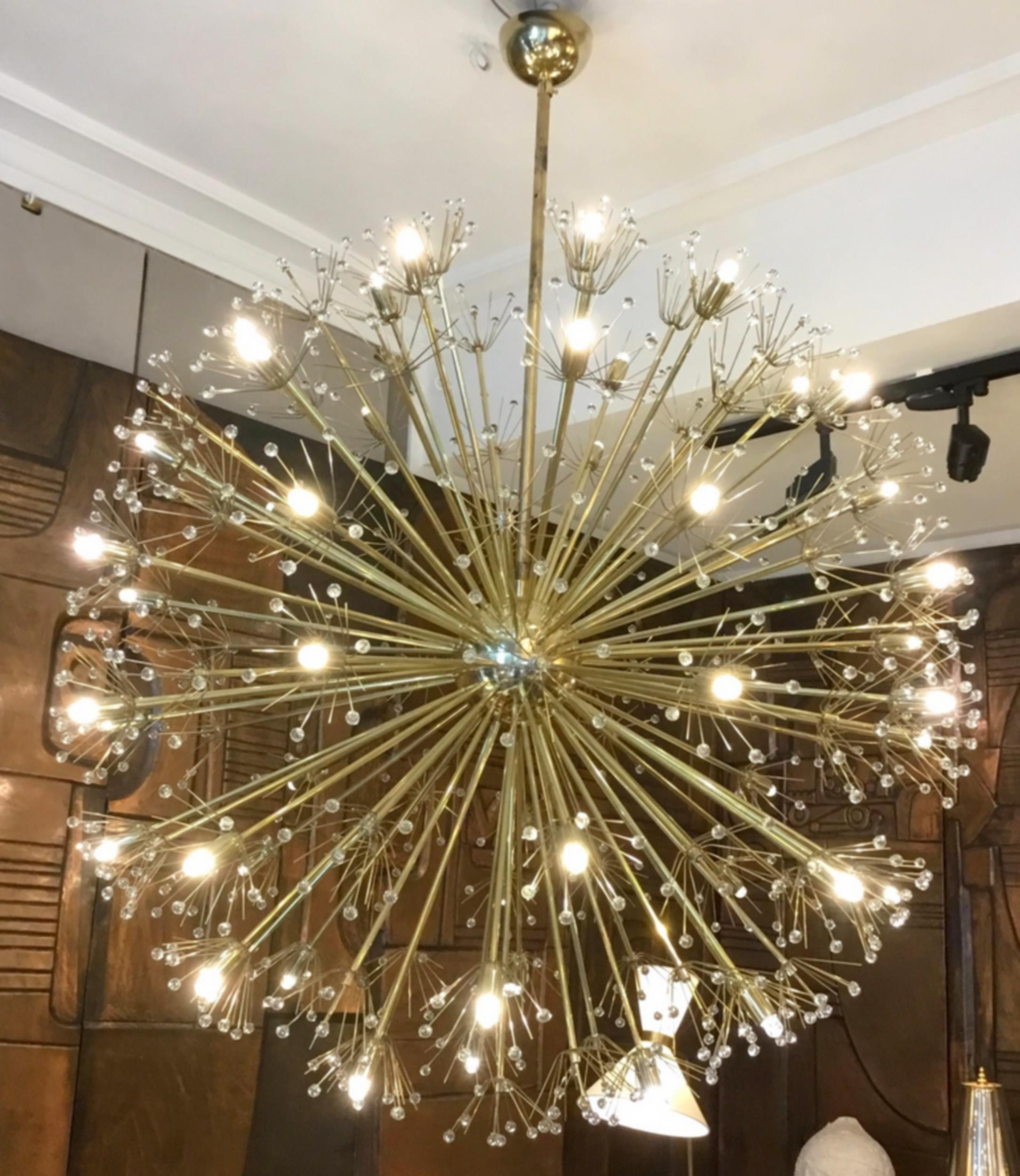 Gran araña de cristal de Murano y latón, hacia 1980.
Una estructura formada por una esfera y varillas de latón sostiene 