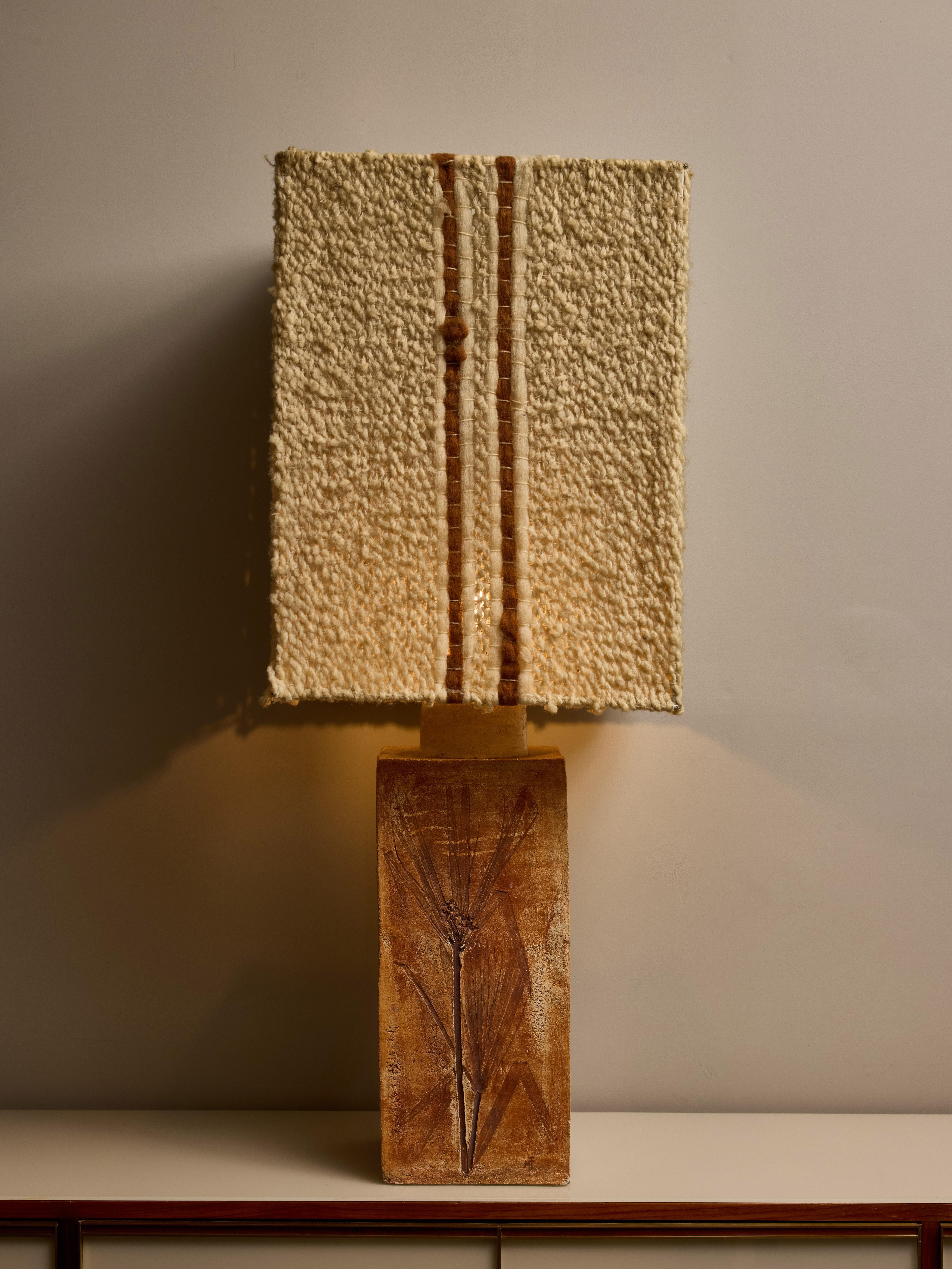 A large, square ceramic table lamp adorned with floral decorations, known as 
