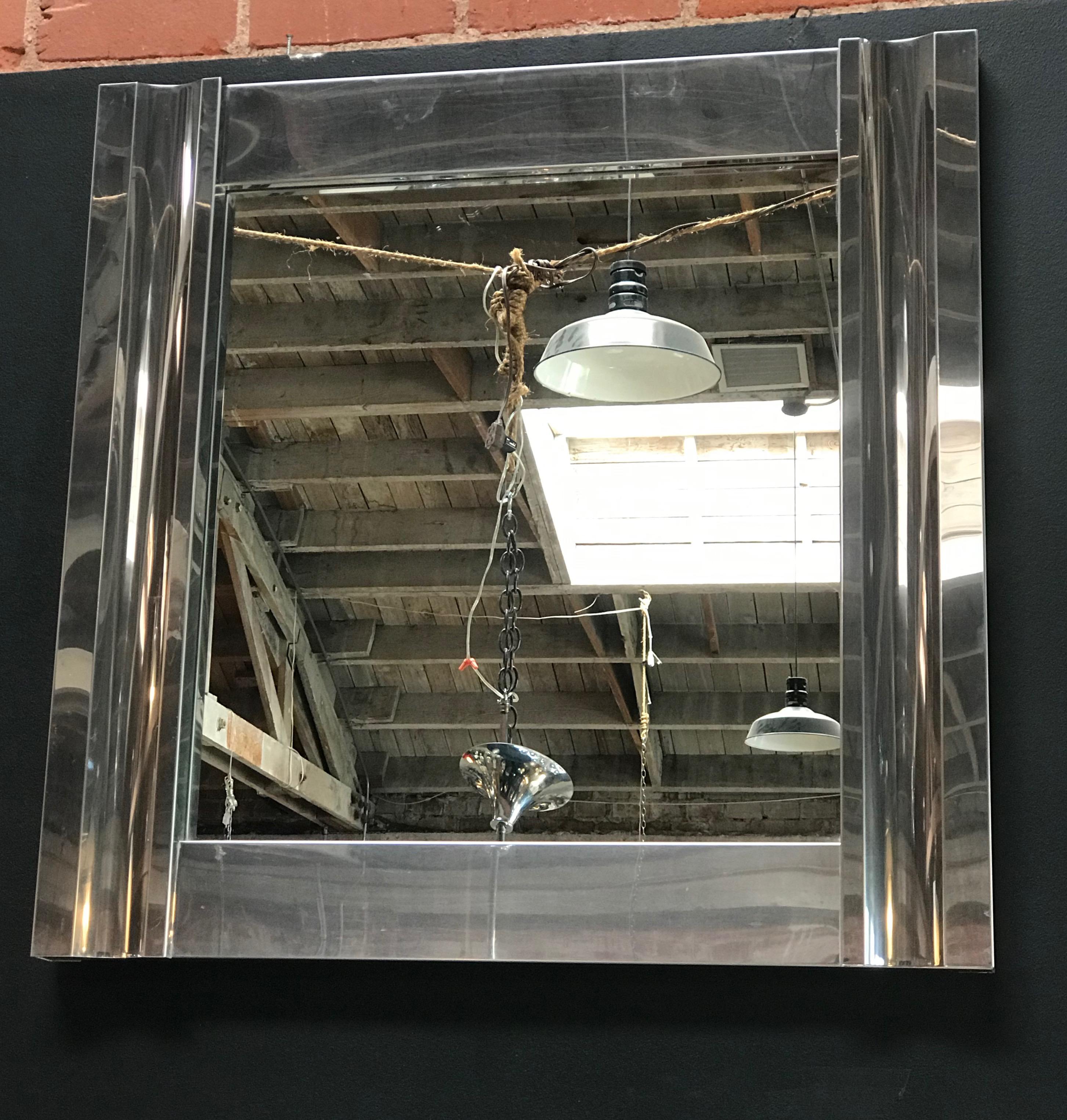 A large square mirror with a thick and chrome-plated sheet sculptural metal frame in a good condition. The design of this 1970s mirror is Minimalist and ahead of its time.