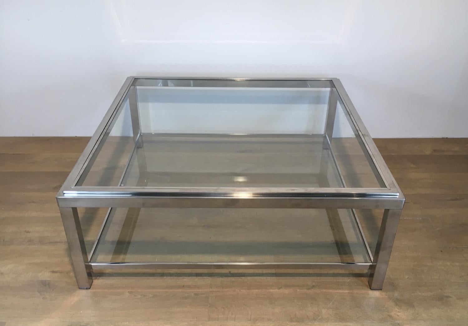 Cette très belle et grande table basse carrée est fabriquée en chrome avec 2 étagères en verre. L'étagère supérieure en verre est non encadrée dans un cadre chromé. Il s'agit d'un ouvrage français. Circa 1970