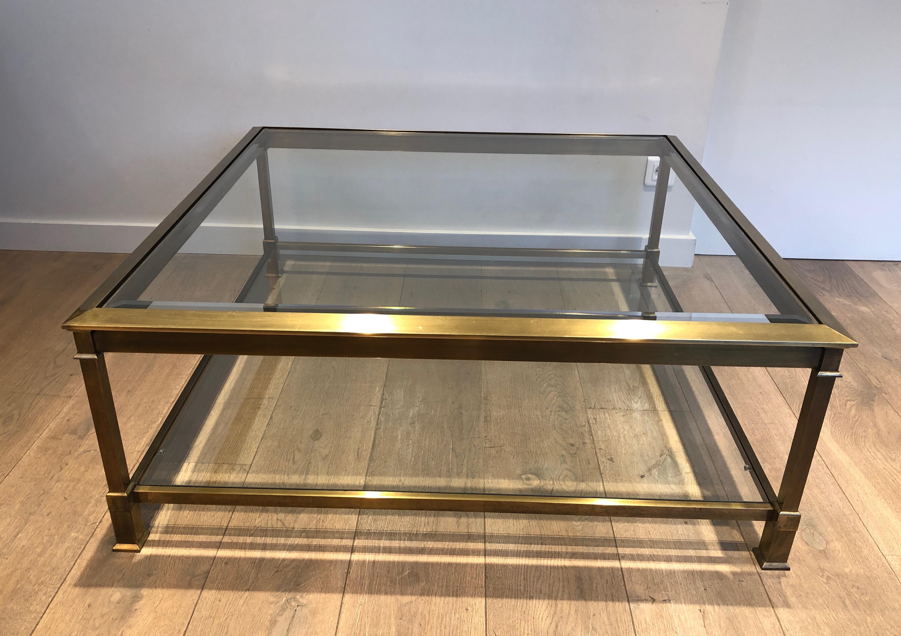 Dieser große quadratische Couchtisch ist aus goldfarben patiniertem Stahl gefertigt und mit zwei Glasablagen versehen. Dies ist ein französisches Werk. CIRCA 1970