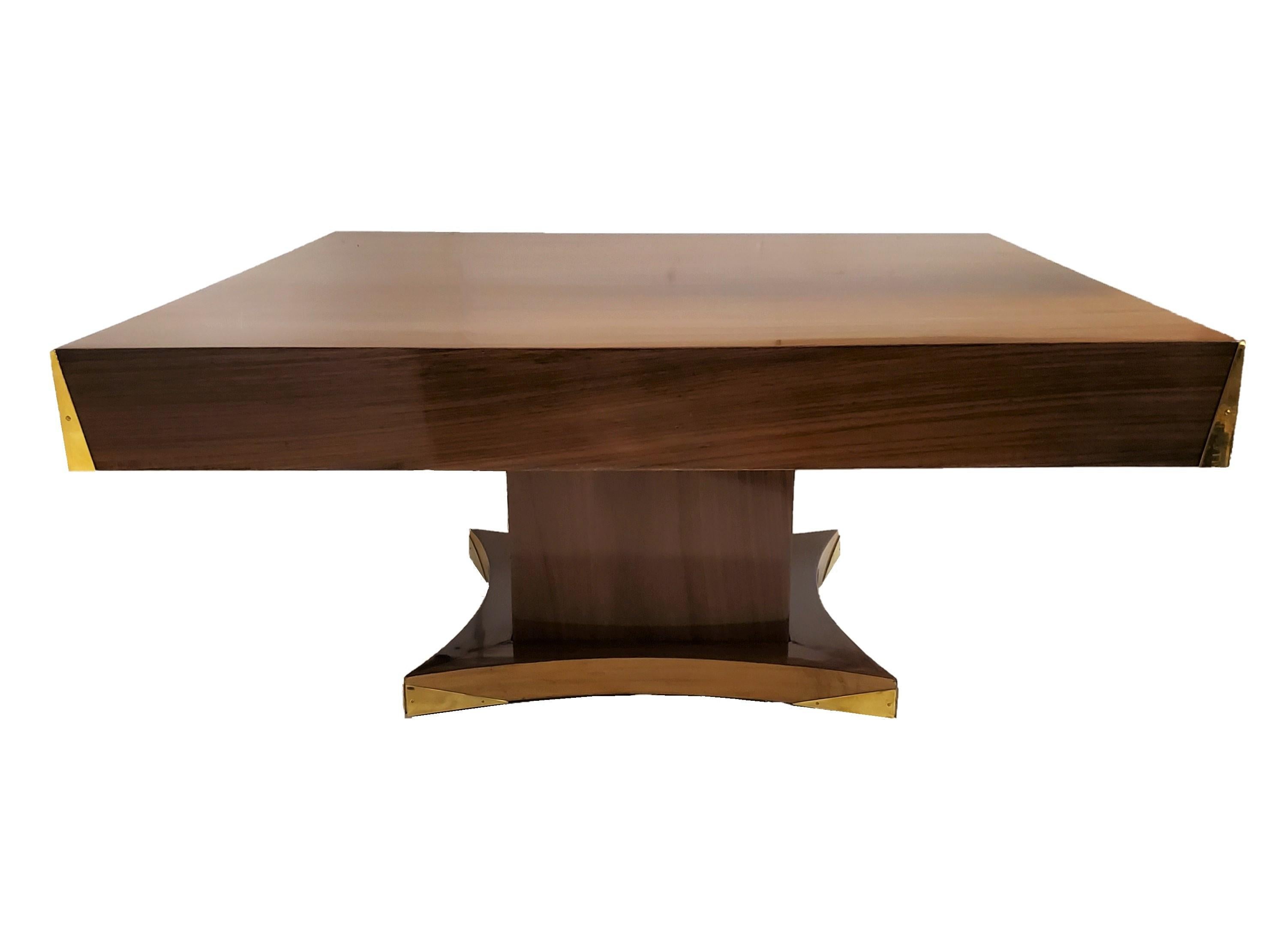 An elegant and imposing cubist design palisander and brass Art Deco square coffee table with square central shaft ending with a radius shape lighter wood sub-base surround. 
Beautifully grained palisander enhances the top surface while the entirety