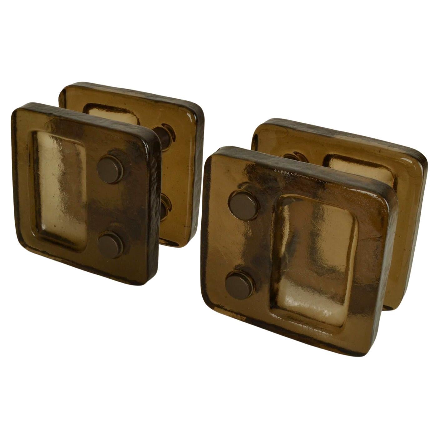 Pair of caramel brown translucent glass cast square glass push and pull door handles with bronze color fittings designed for double doors, 1970's.
The process to cast glass is by directing molten glass into a mold where it solidifies. Ancient