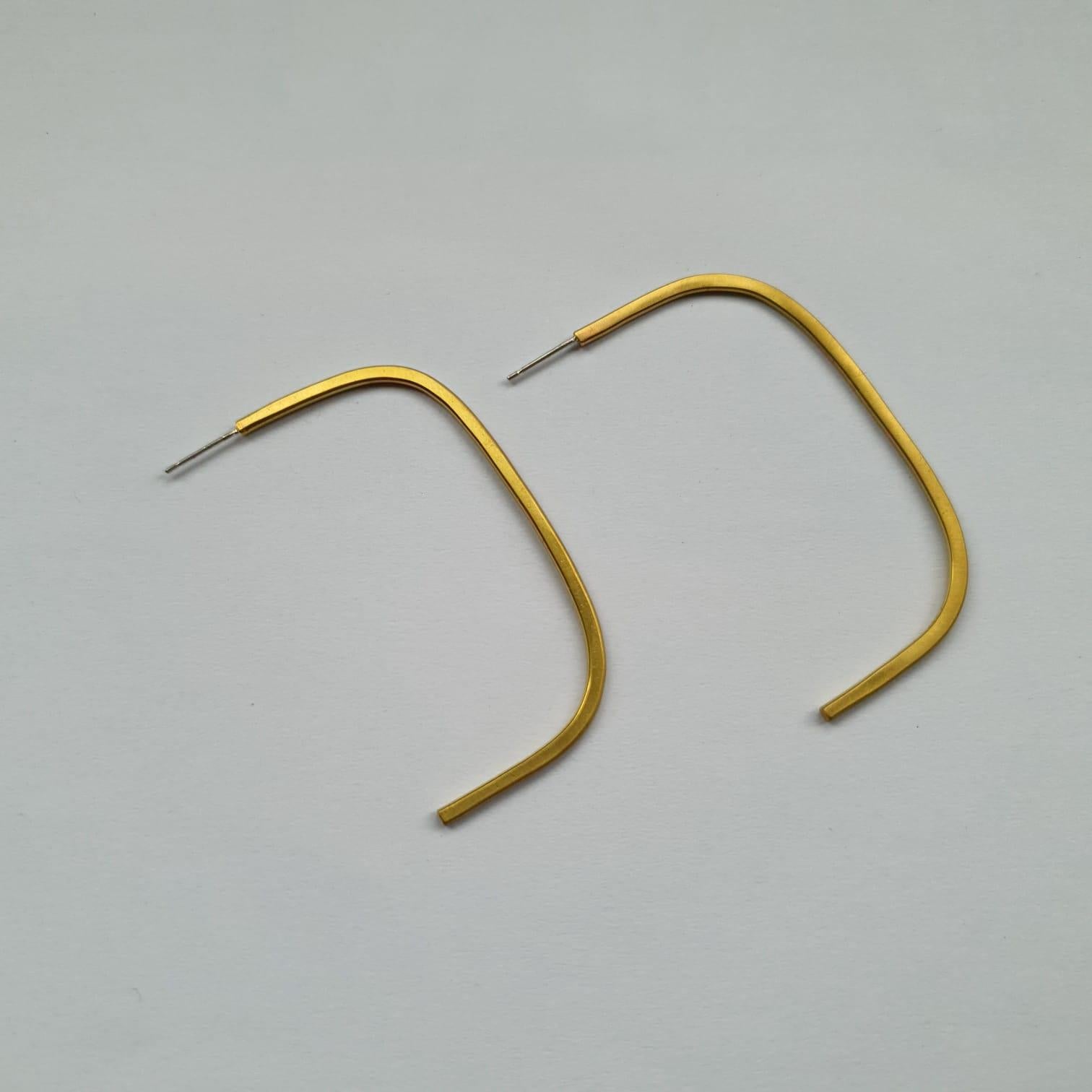 Elegant stud earrings made from forged brass wire, formed into a half folded square. 

The polished inside surface catches the light when worn. 

They are secured to the ear with a classic butterfly back, and are a comfortable weight for everyday