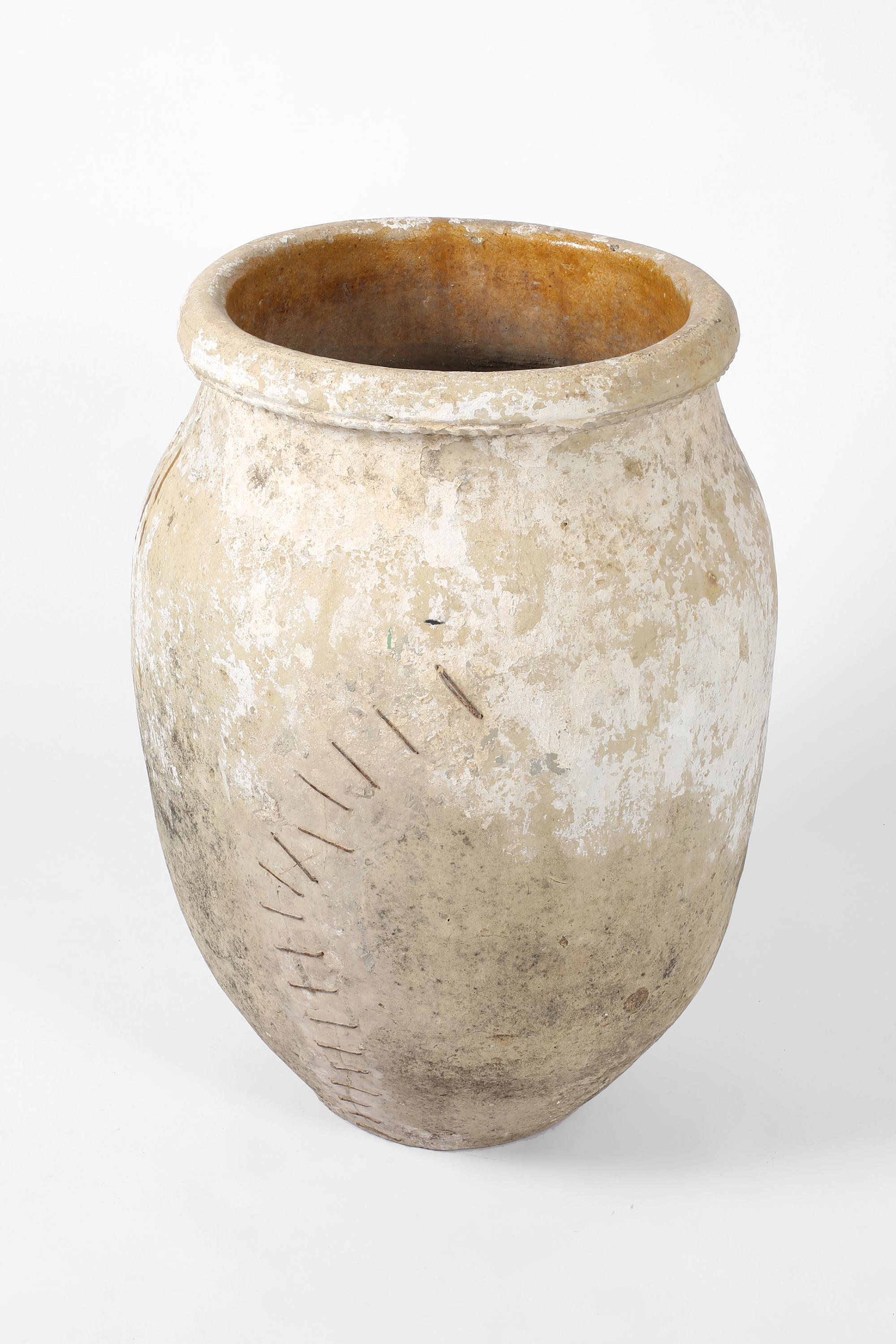 A large and fantastically patinated earthenware jar with characterful iron staple repairs and remnants of lime. From the province of Córdoba in Andalusia. Spanish, c. 1800.