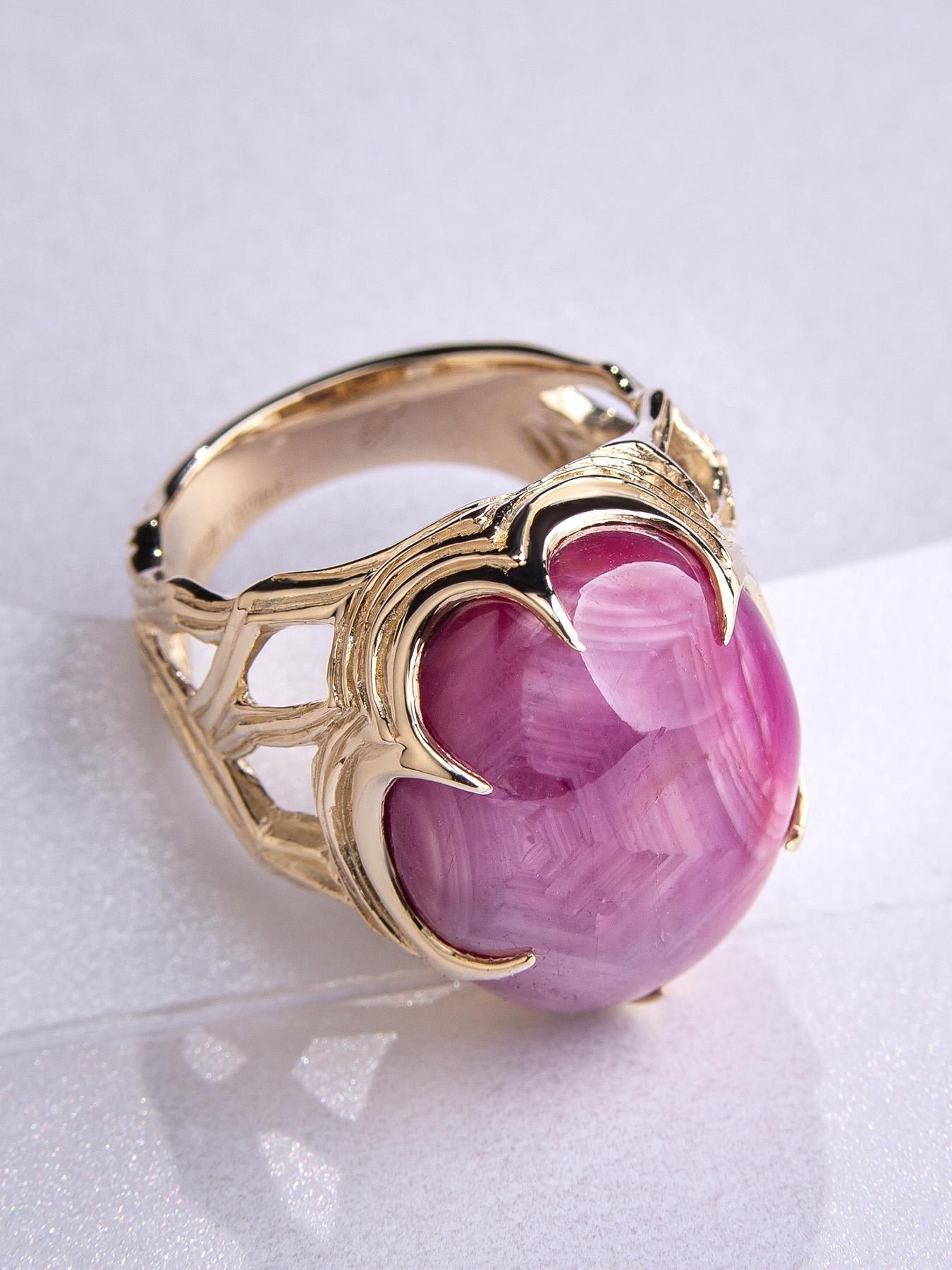 Ein wunderschöner Ring aus 14 Karat Gelbgold, besetzt mit einem natürlichen Sternrubin aus Sri Lanka. Dieser große Edelstein im Cabochon-Schliff wiegt 33,85 Karat und zeigt einen leuchtenden sechsstrahligen Stern, wenn sich das Licht über ihn