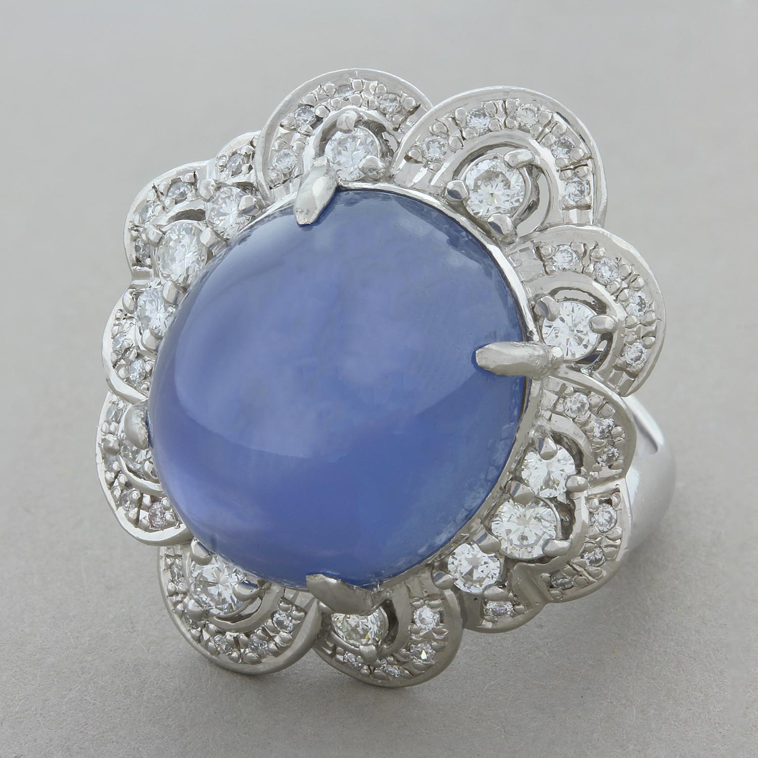 This distinguished ring features a 30.14 carat cabochon star sapphire with a lovely velvety blue hue. The star sapphire gives life to this extravagant ring set in platinum with a swirling halo of 1.24 carats of diamonds creating a classic and