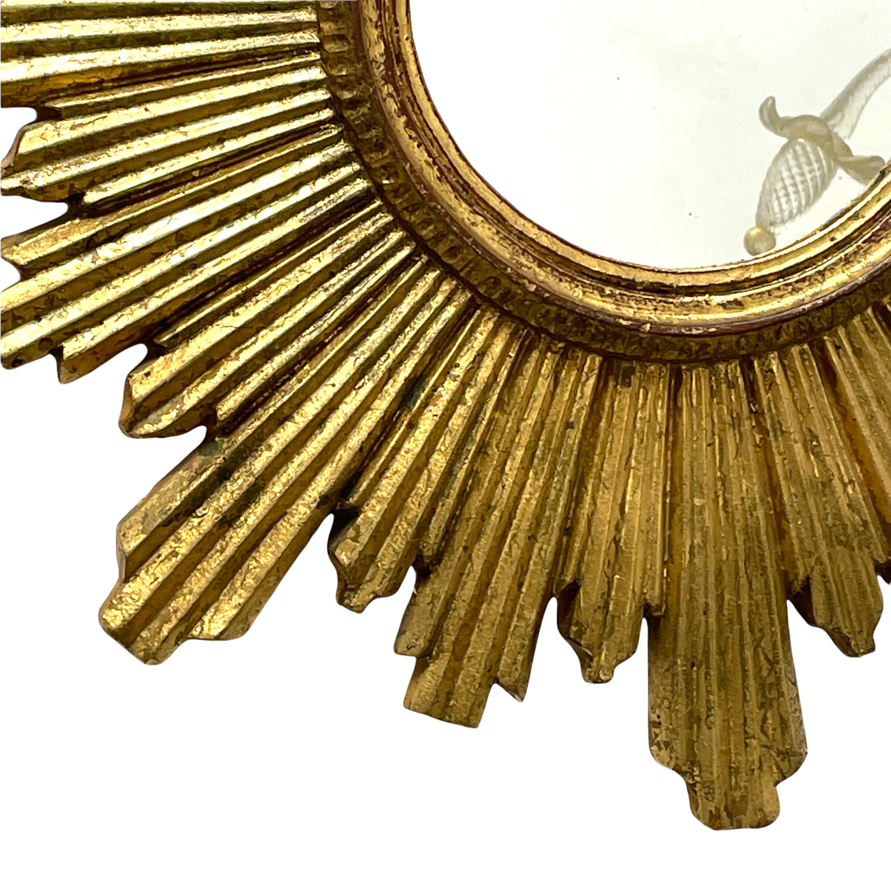 A gorgeous starburst sunburst mirror. Made of gilded wood and stucco. It measures approximate: 23