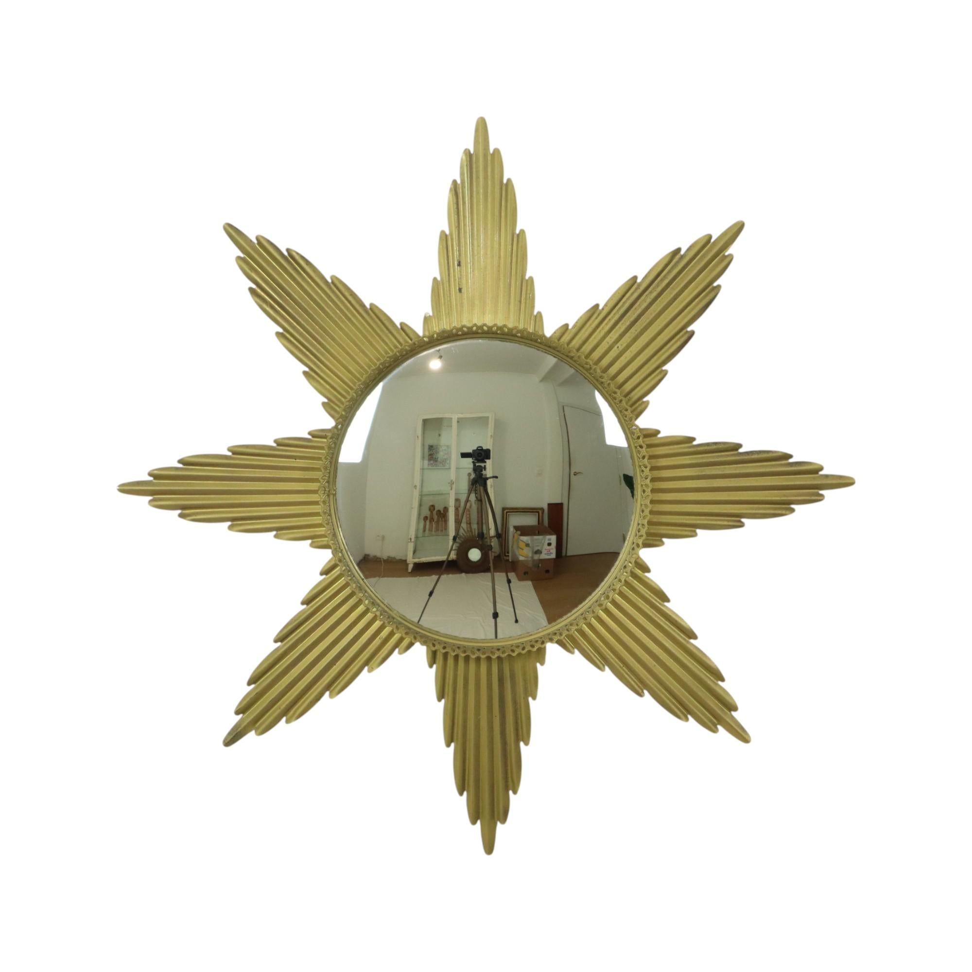 Large vintage starburst, sunburst or sun mirror with convex mirror glass, made of gold-colored wavy metal and wood, a decorative metal edge is applied around the mirror, design object from the 1960s.

In good vintage condition, the metal has