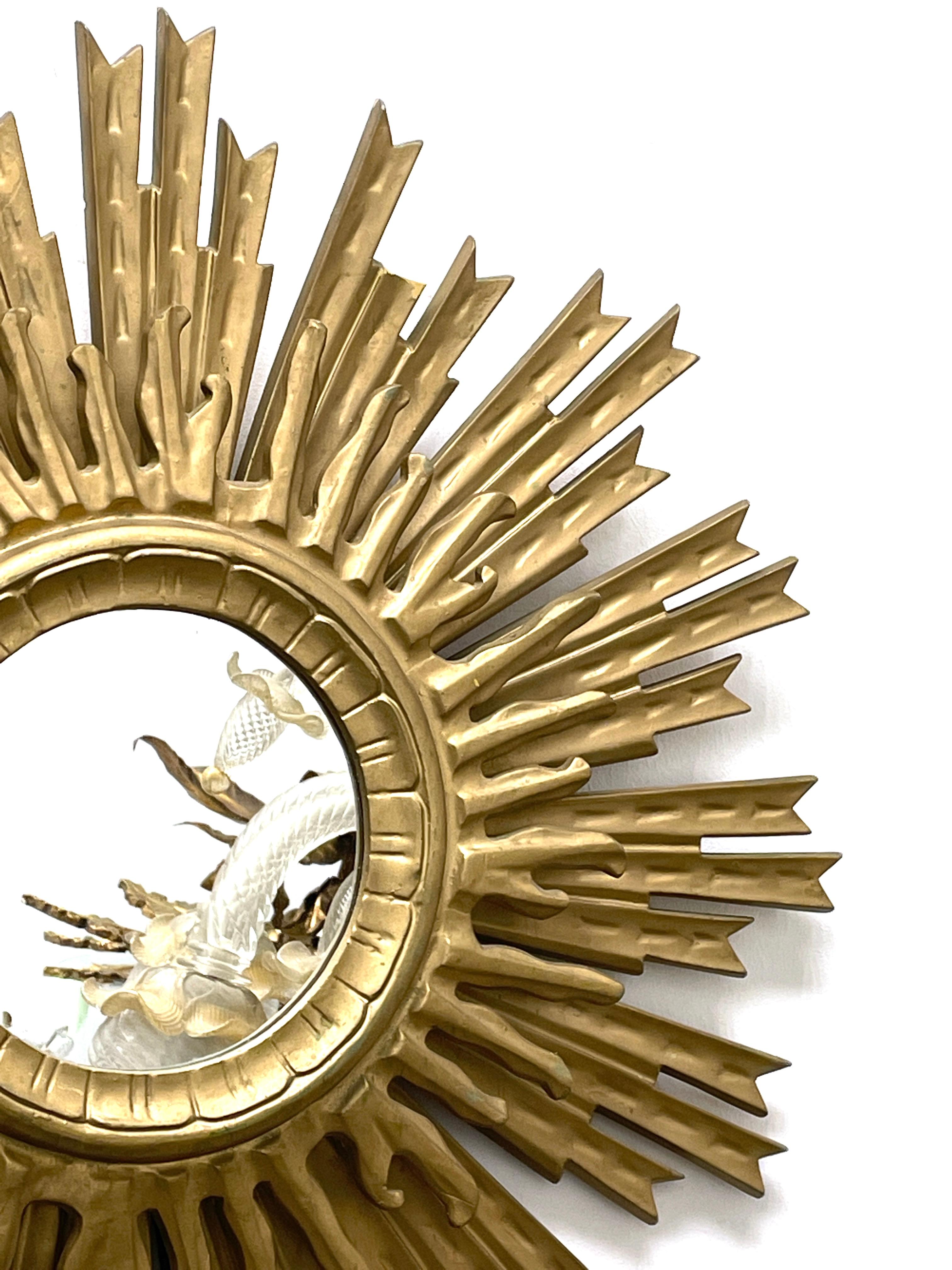 A beautiful starburst sunburst mirror. Made of gilded plastic. It measures approximate 26 1/4