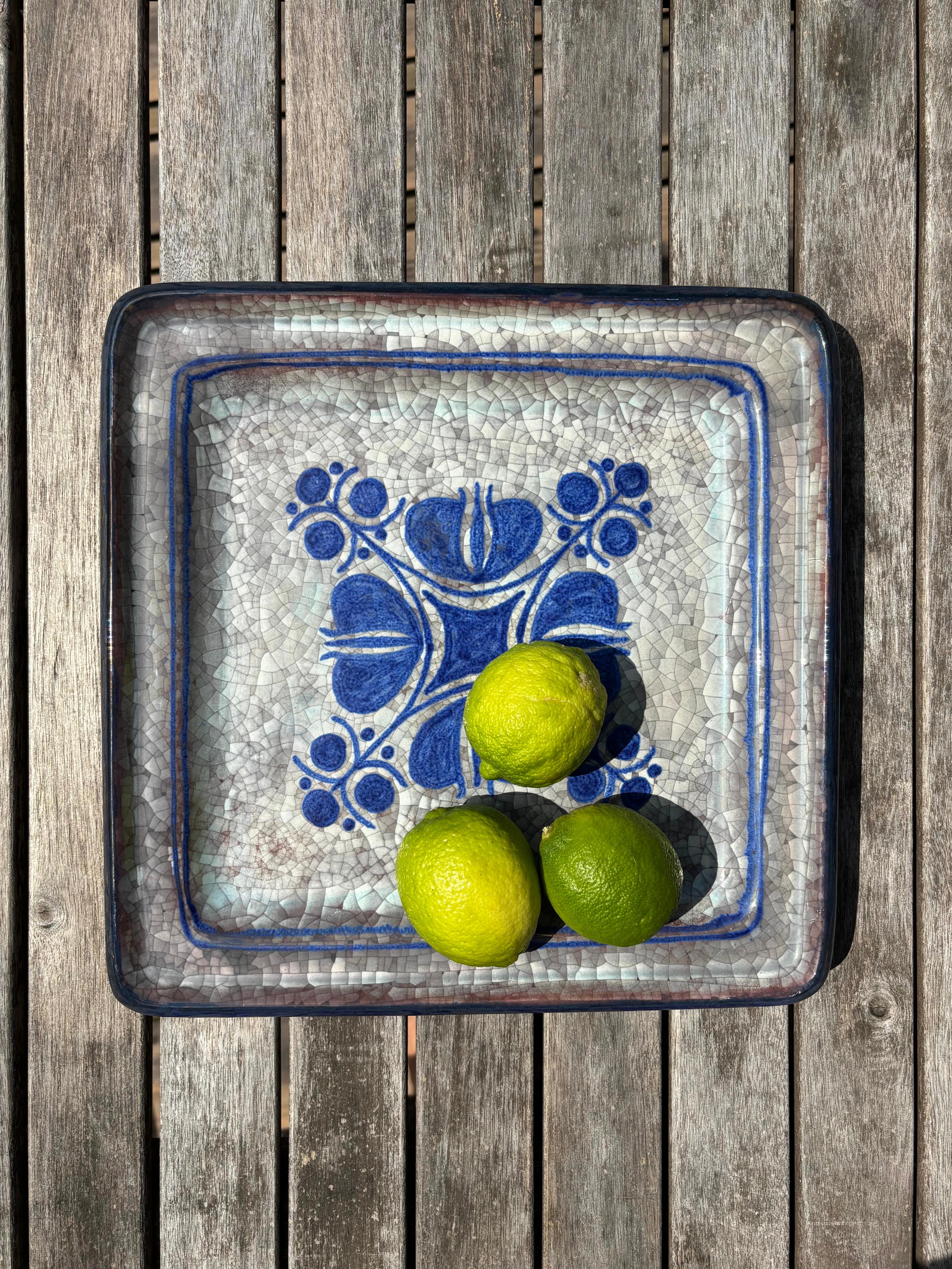 Handmade Danish midcentury modern decorative plate. Decorated by hand with blue lines and floral shapes over white and warm gray persia crackle glaze. Designed by Marianne Starck for Michael Andersen & Son, and manufactured on the island of Bornholm