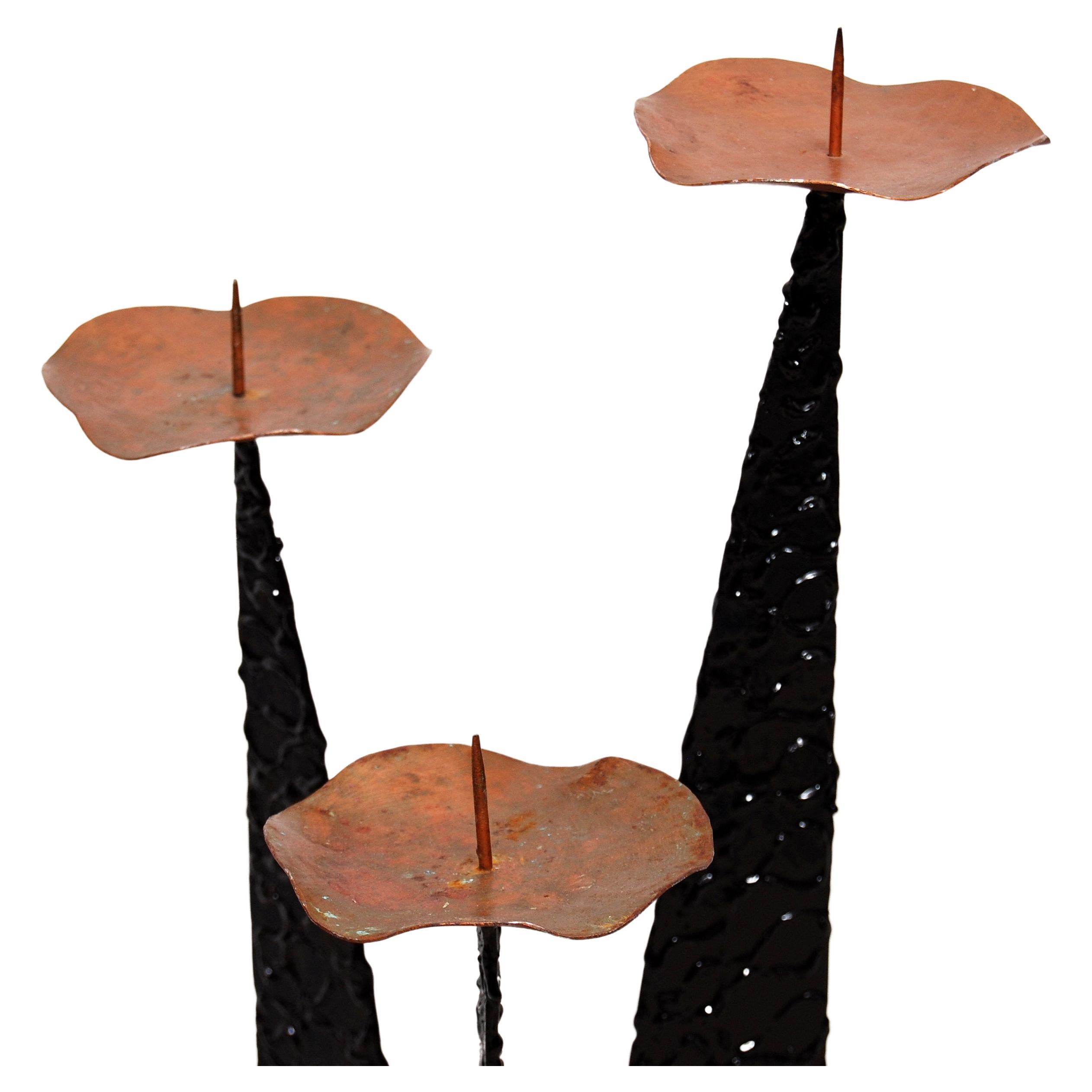A welded steel Brutalist candle holder in the manner of Paul Evans. It can accommodate three candles at three different heights.
 