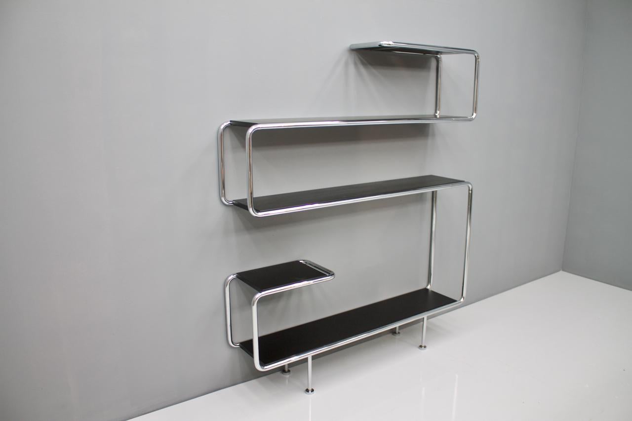 Very high-quality steel tube wall shelf which is arranged in different heights. The chrome-plated steel and the painted wooden floors are very high-quality and heavy.
All four legs can be adjusted in height.