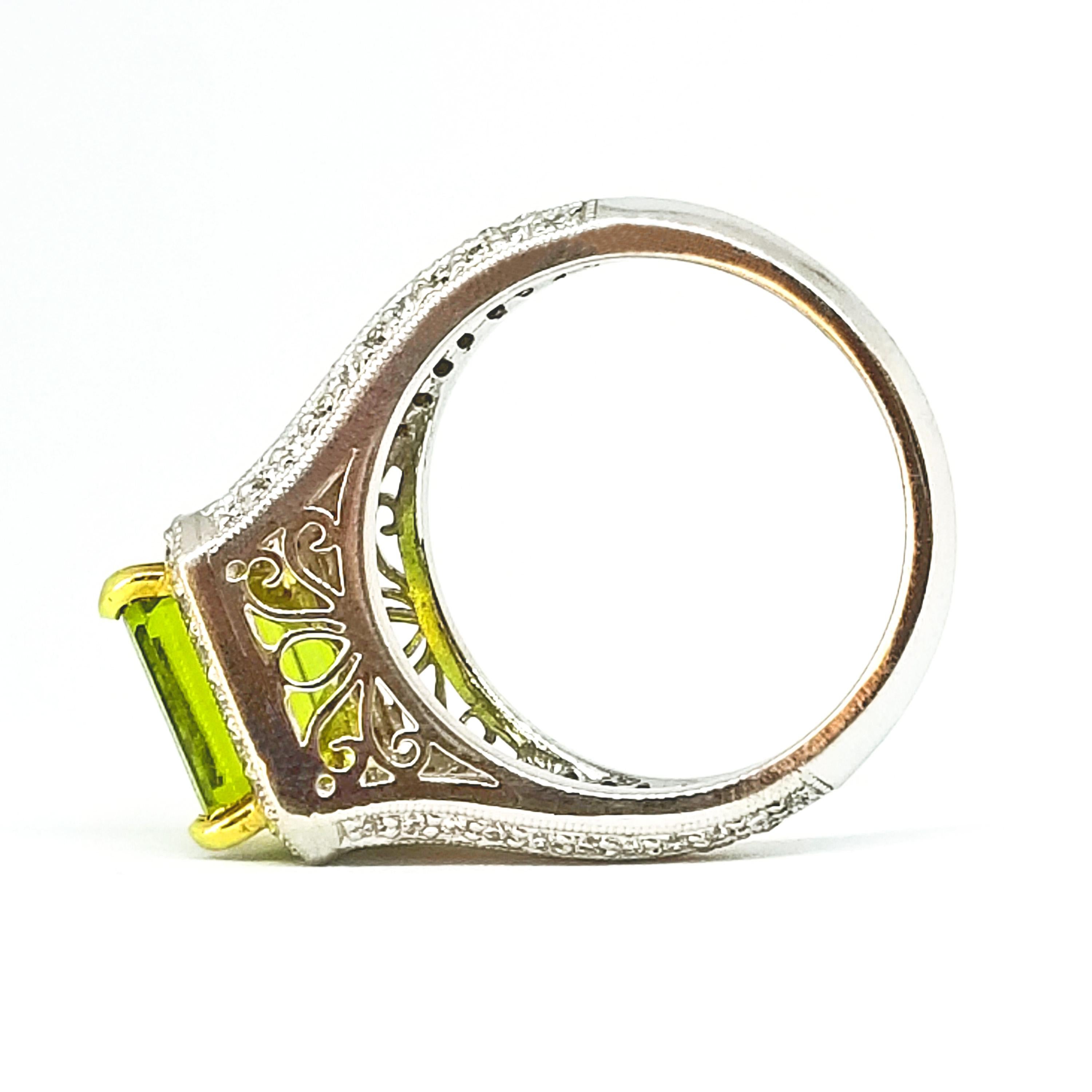 This Stately Cocktail Ring is set with a 3.55 Carat Square Step Cut Burmese Peridot. The Gem Quality stone is of Rich Green hue and is set in four heavy prongs above a Platinum square Halo of Round Brilliant Diamonds. Round Brilliant Diamonds