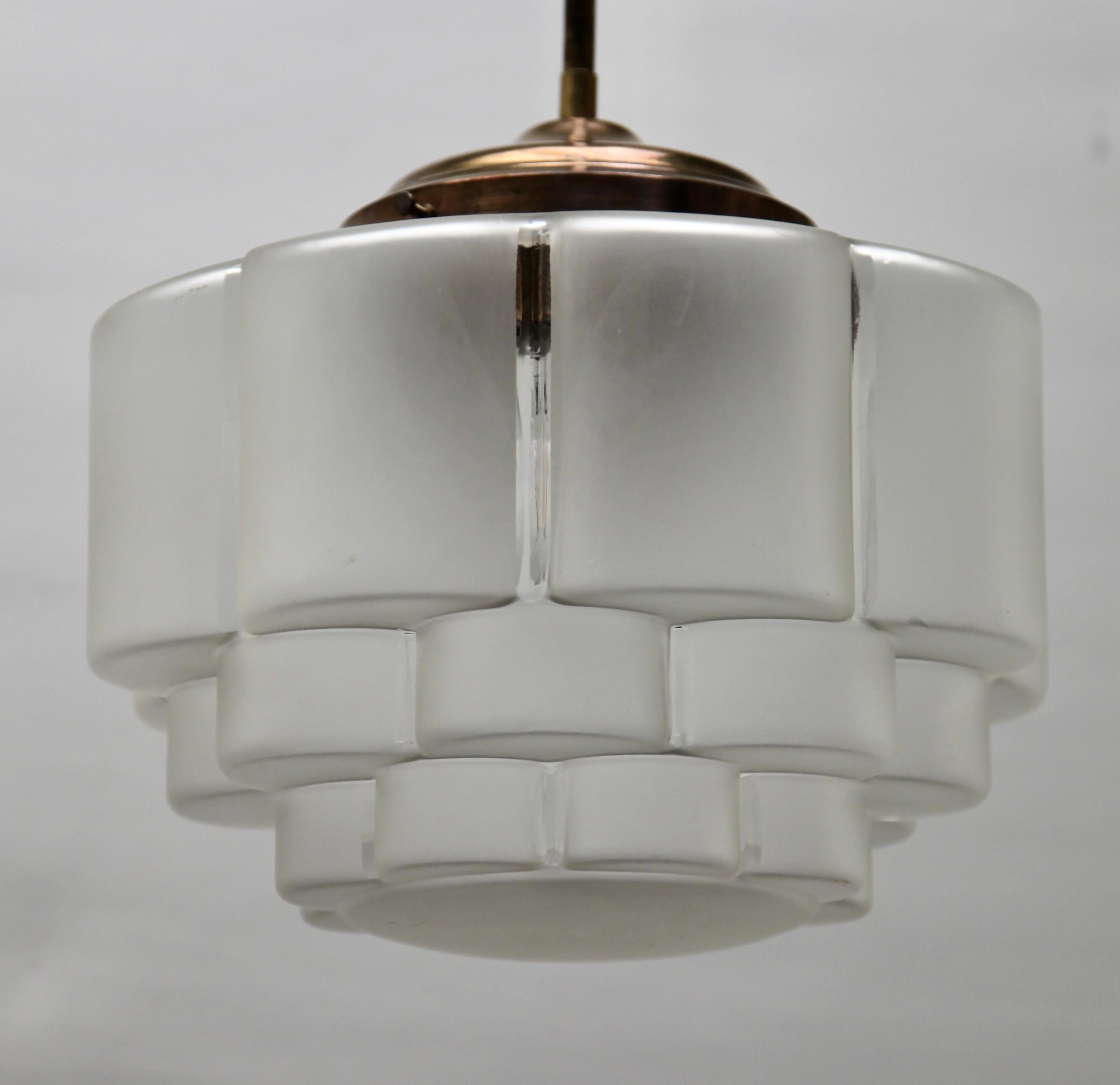 Large stepped satin glass and brass fittings pendant light, the 1930s

Provided with new fittings E27 max 60-watt Bulb
With original patina on brass parts.
In excellent condition and in full working order. 
And safe for usage in the World.

Size