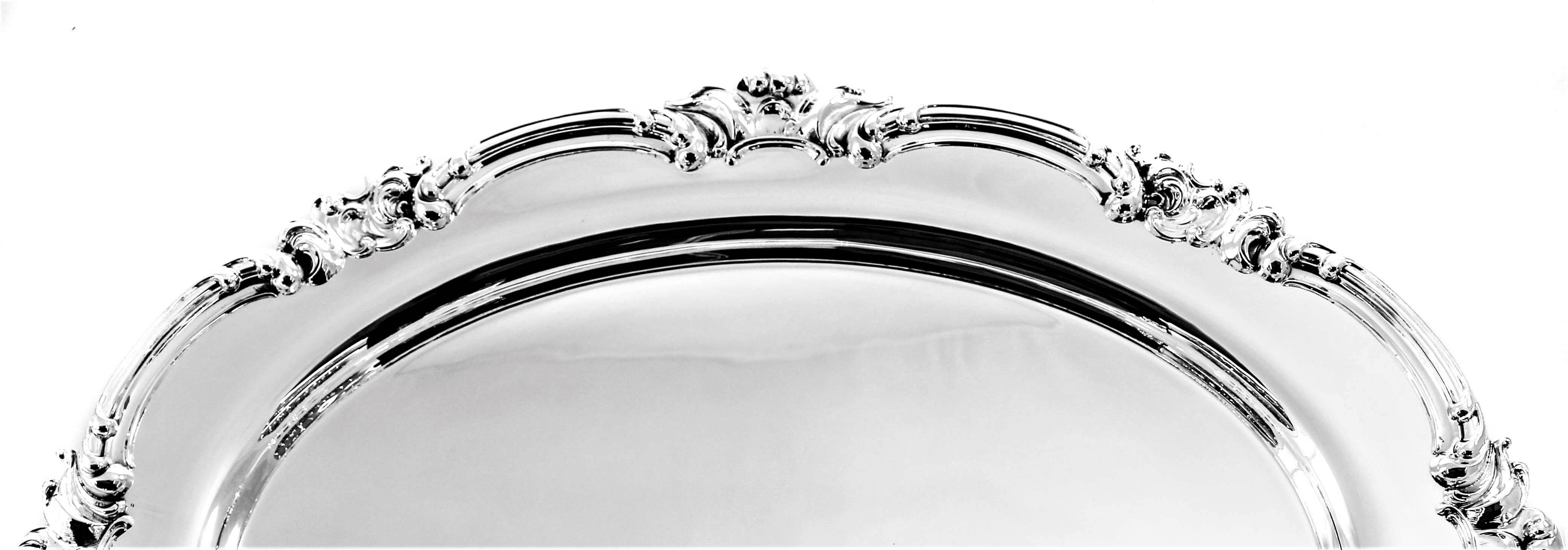 If you’re looking for a large and impressive sterling platter, this is for you. It is oval in shape with a scalloped rim. Along the edge there is a decorative pattern of swirls that gives this piece a rich and ornate look. The center is flat and