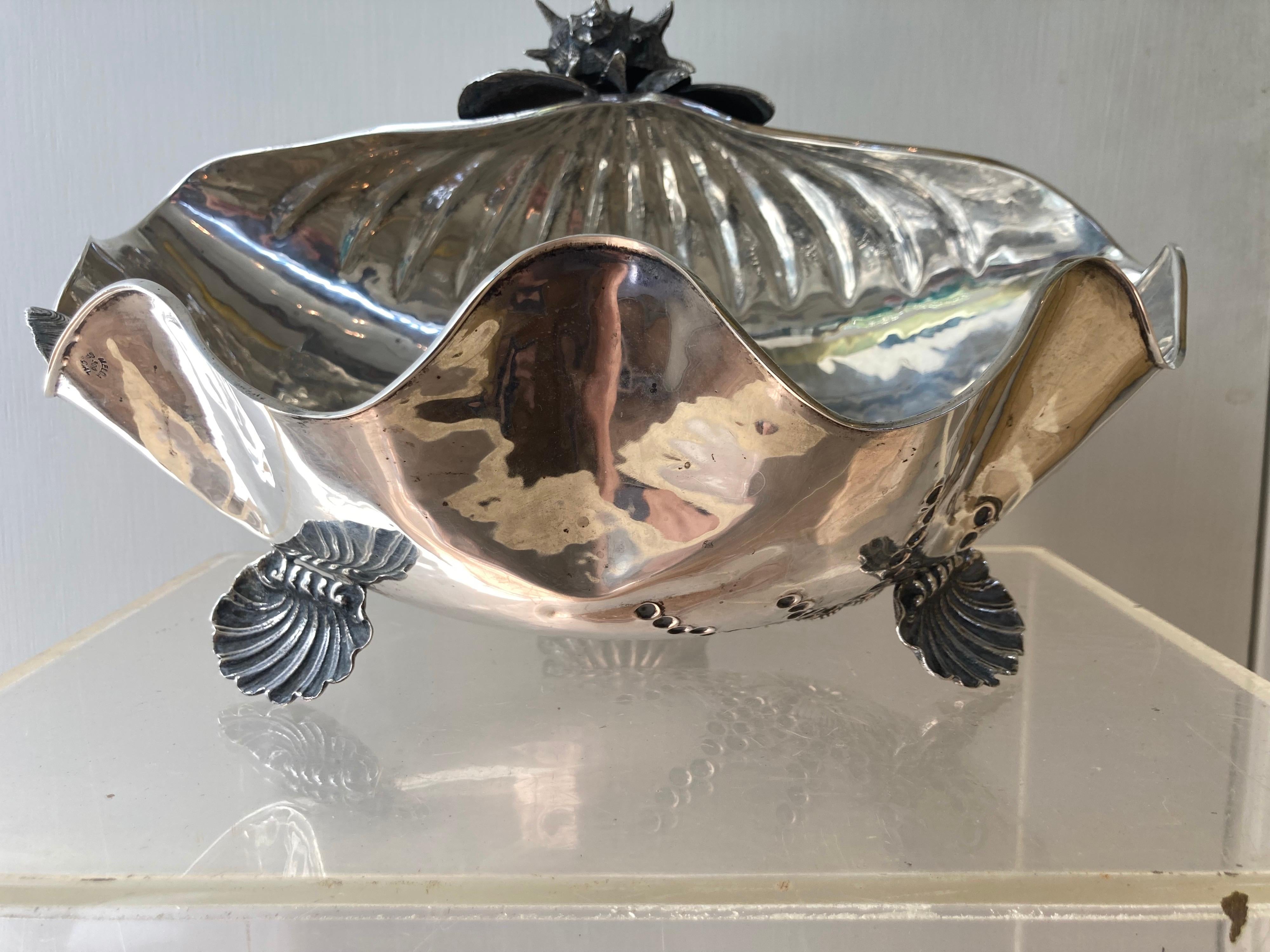 An exceptionally beautiful grotto style sterling silver conch shell embellished with additional shells on a tripod base of three shells... stamped and in very good condition.