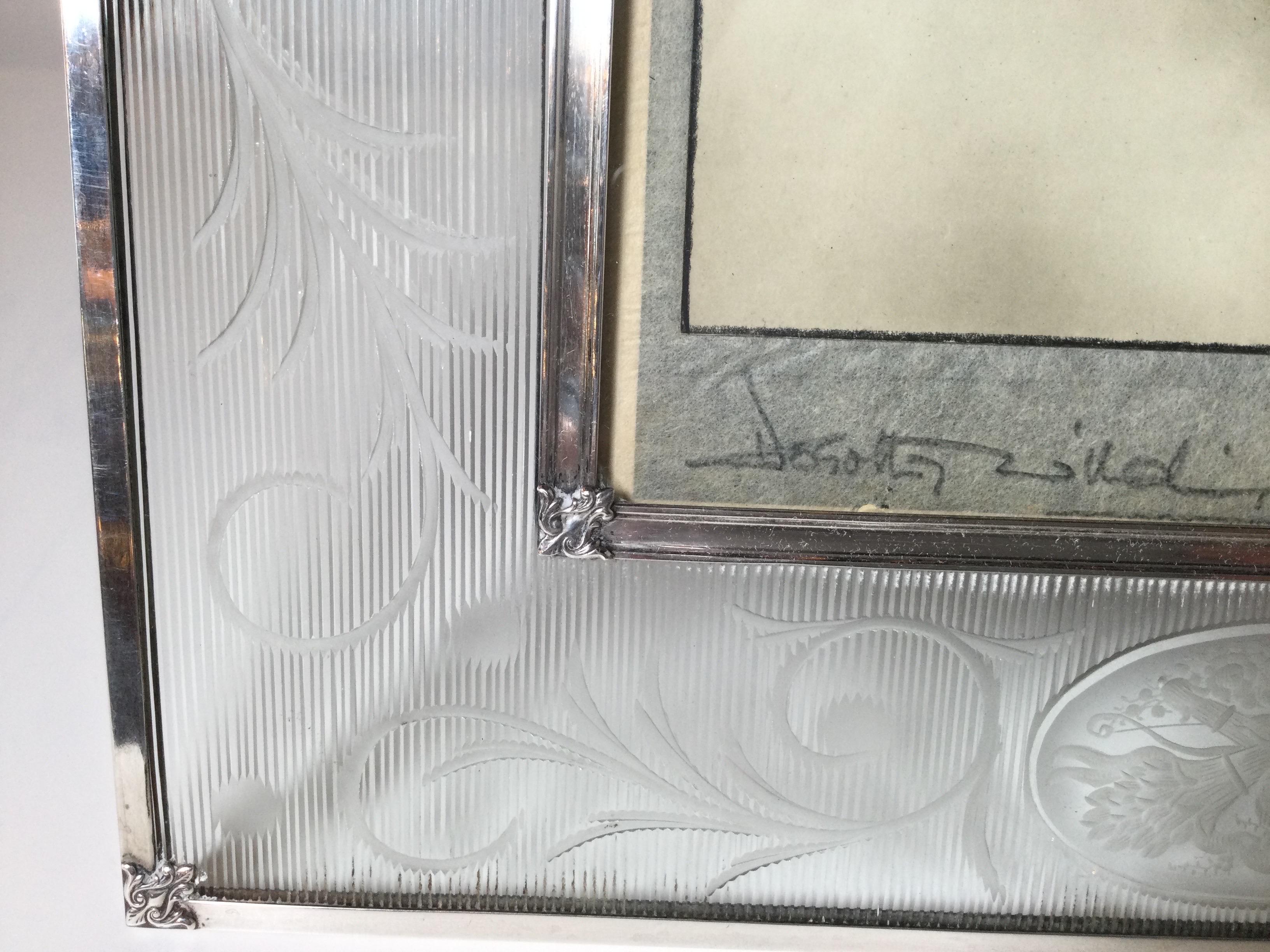 An elegant sterling silver and engraved glass picture frame with a movie star photo included. The frame edged in sterling with engraved glass panels. The photo signed by a renowned photographer, Dorothy Wilder and signed.