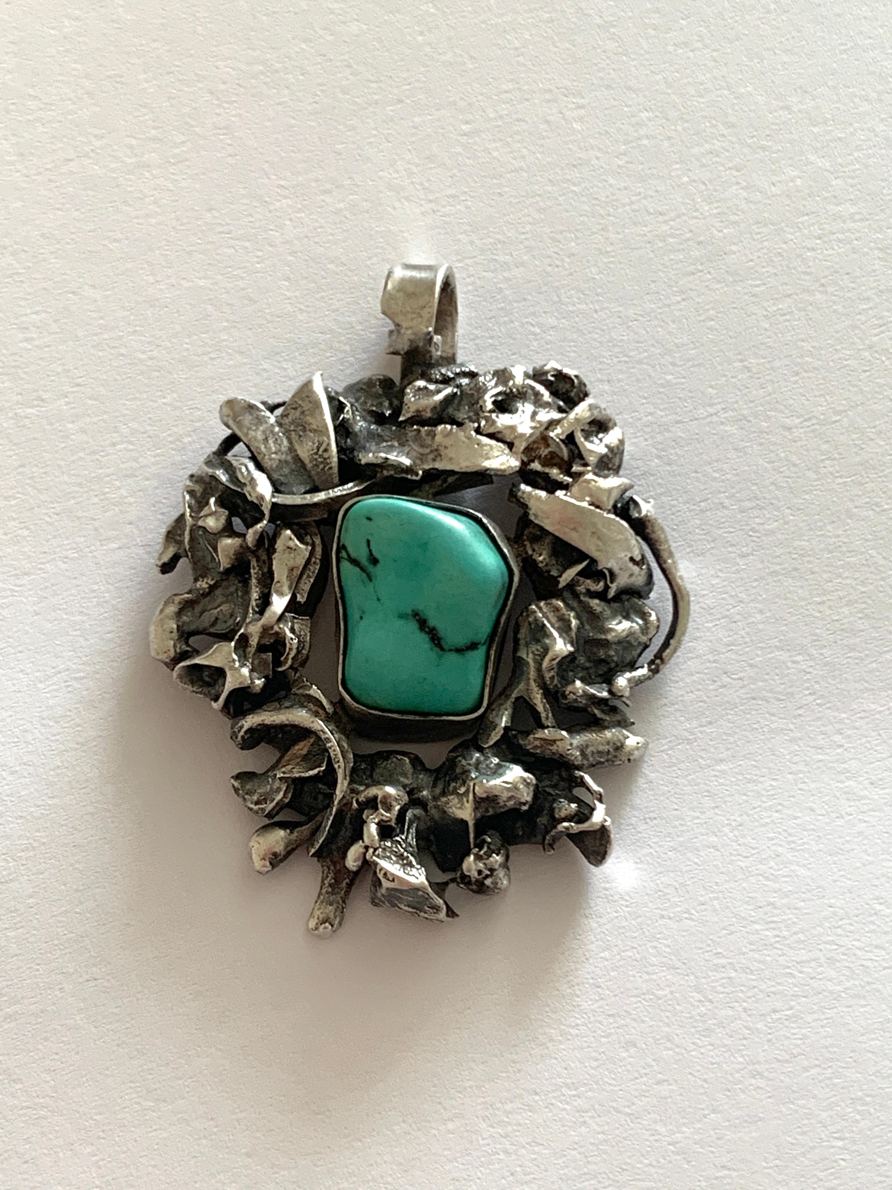 Beautiful Handmade Sterling Silver Brutalist Pendant
with a luxuriously smooth central turquoise stone.

unknown designer
Circa 1970s
Stamped on reverse 
